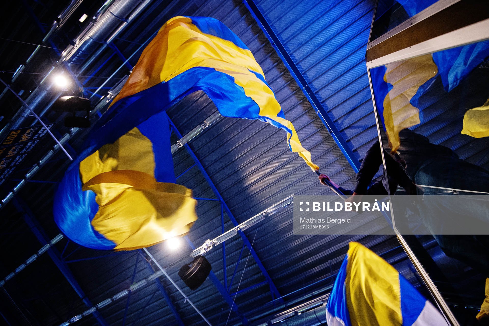 En HV71-supporter vevar med en blågul flagga