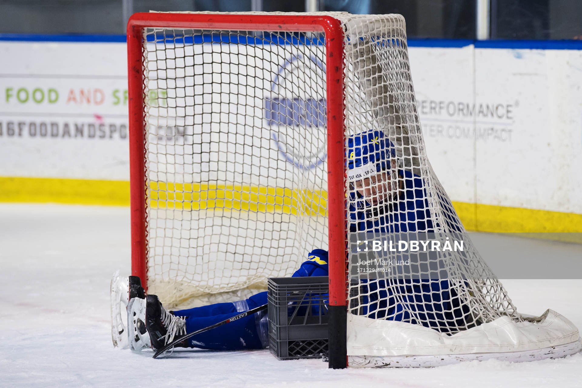Rasmus Dahlin sitter inuti ett mål och plockar ihop puckar