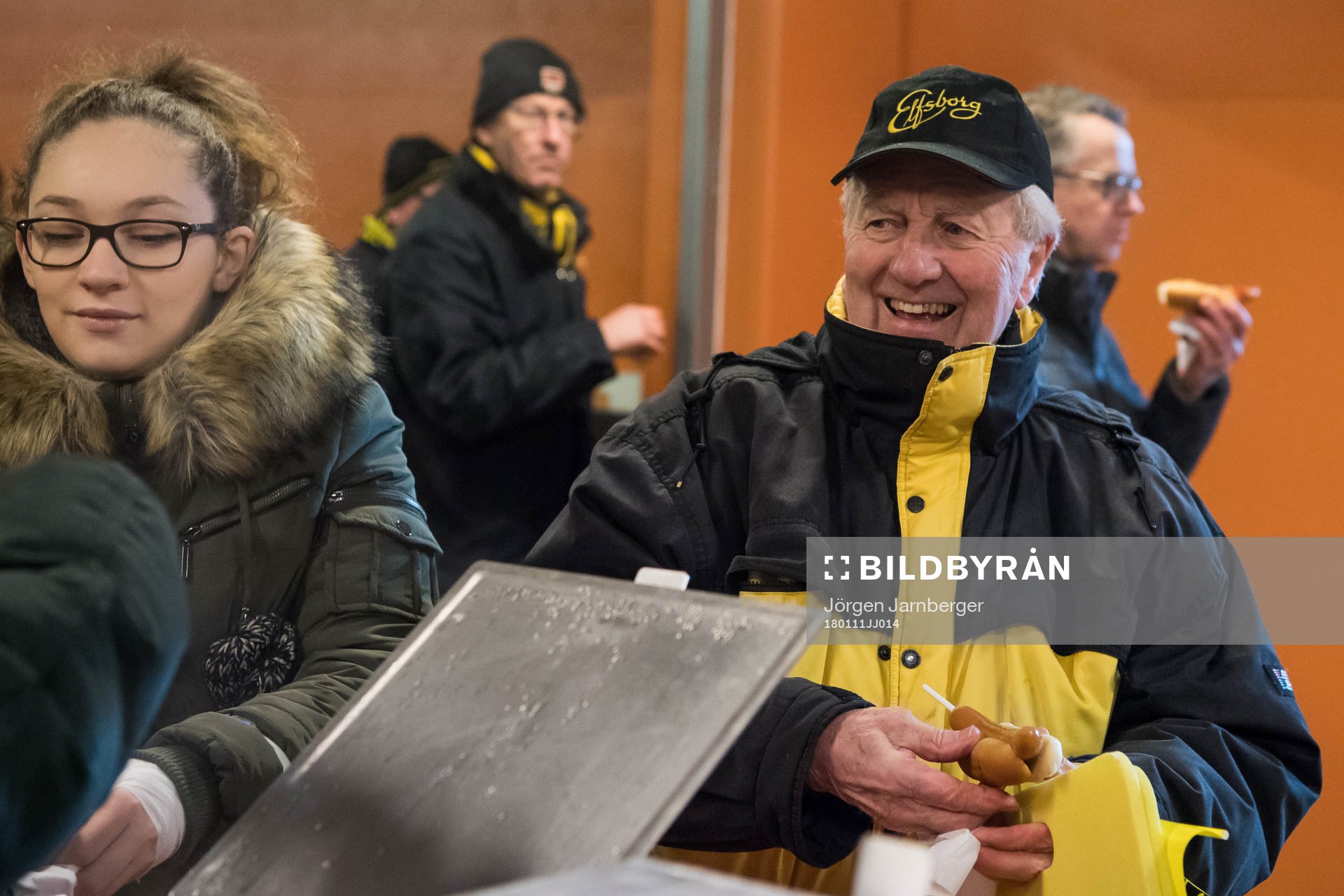 En glad supportar äter korv med bröd