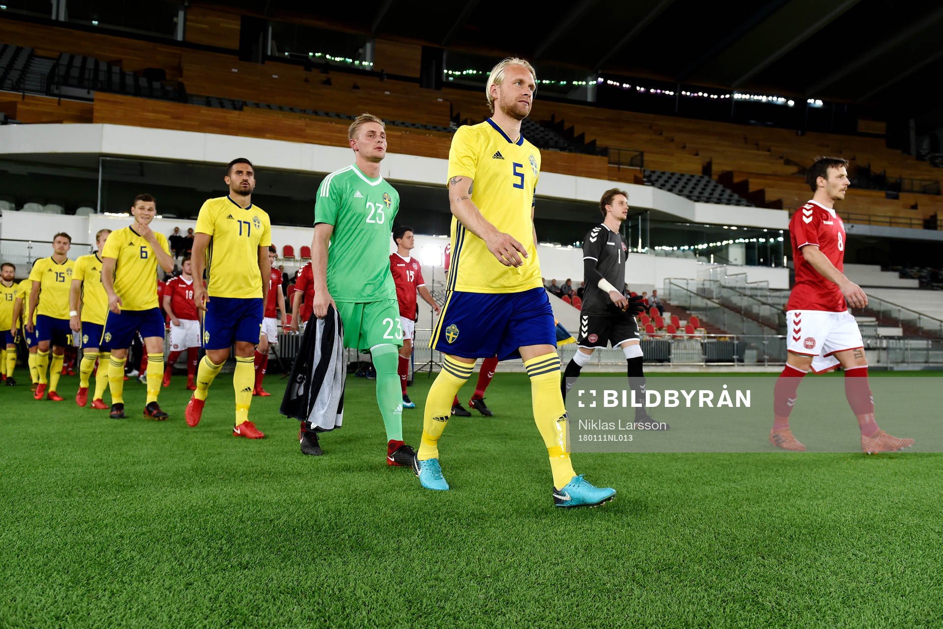 Sveriges och Danmarks spelare går in på plan