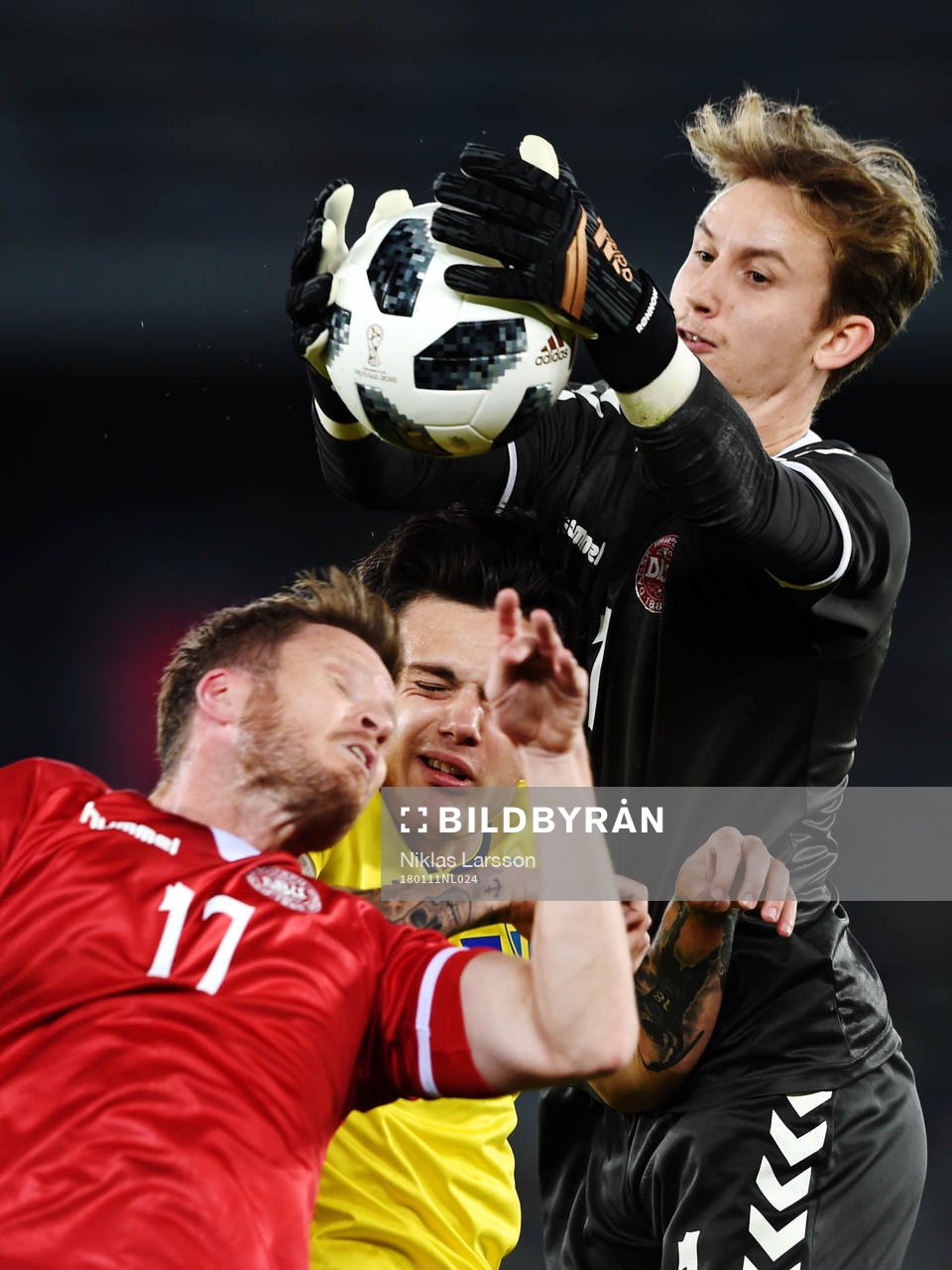 Sveriges David Moberg Karlsson i nickduell med Danmarks Lasse Nielsen och målvakt Fredrik Rønnov under en landskamp mellan Sverige och Danmark på det svenska fotbollslandslagets januariturné den 11 januari 2018 i Abu Dhabi.