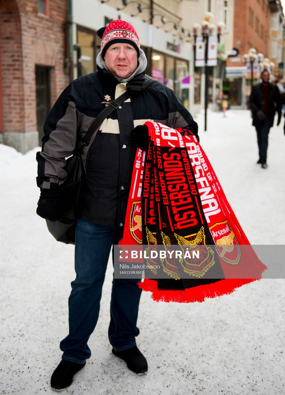 En försäljare säljer halsdukar innan fotbollsmatchen i