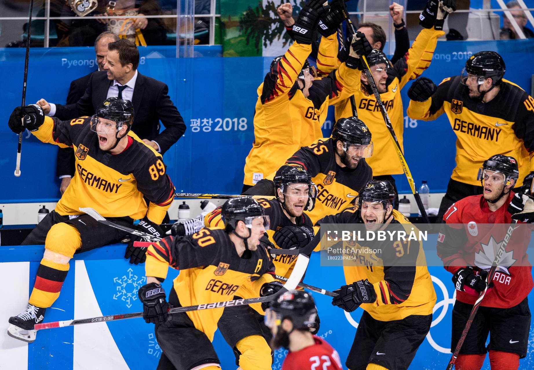 Team Germany celebrates and Mat Robinson of Canada looks