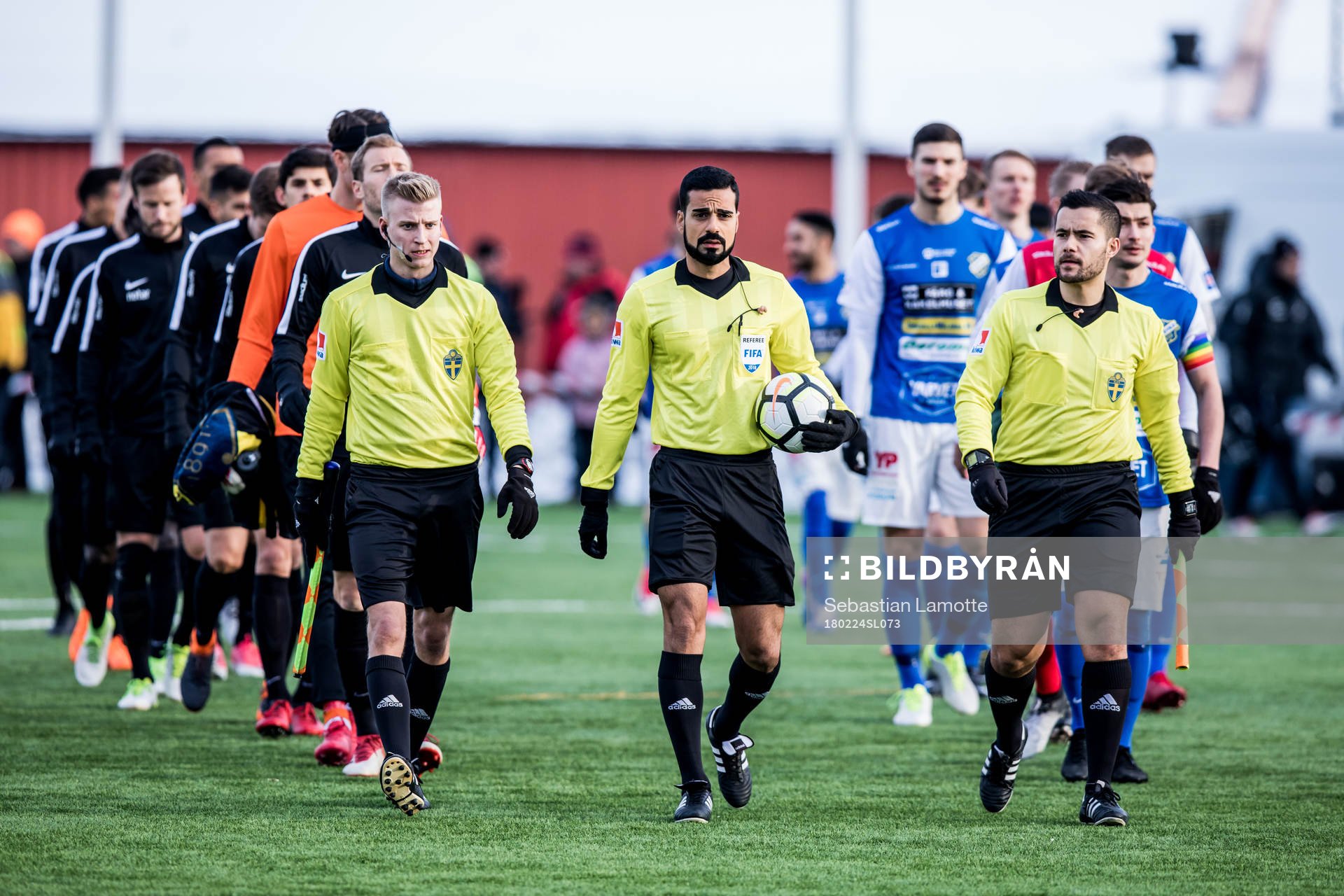 Domare Mohammed Al-Hakim leder in lagen till avspark