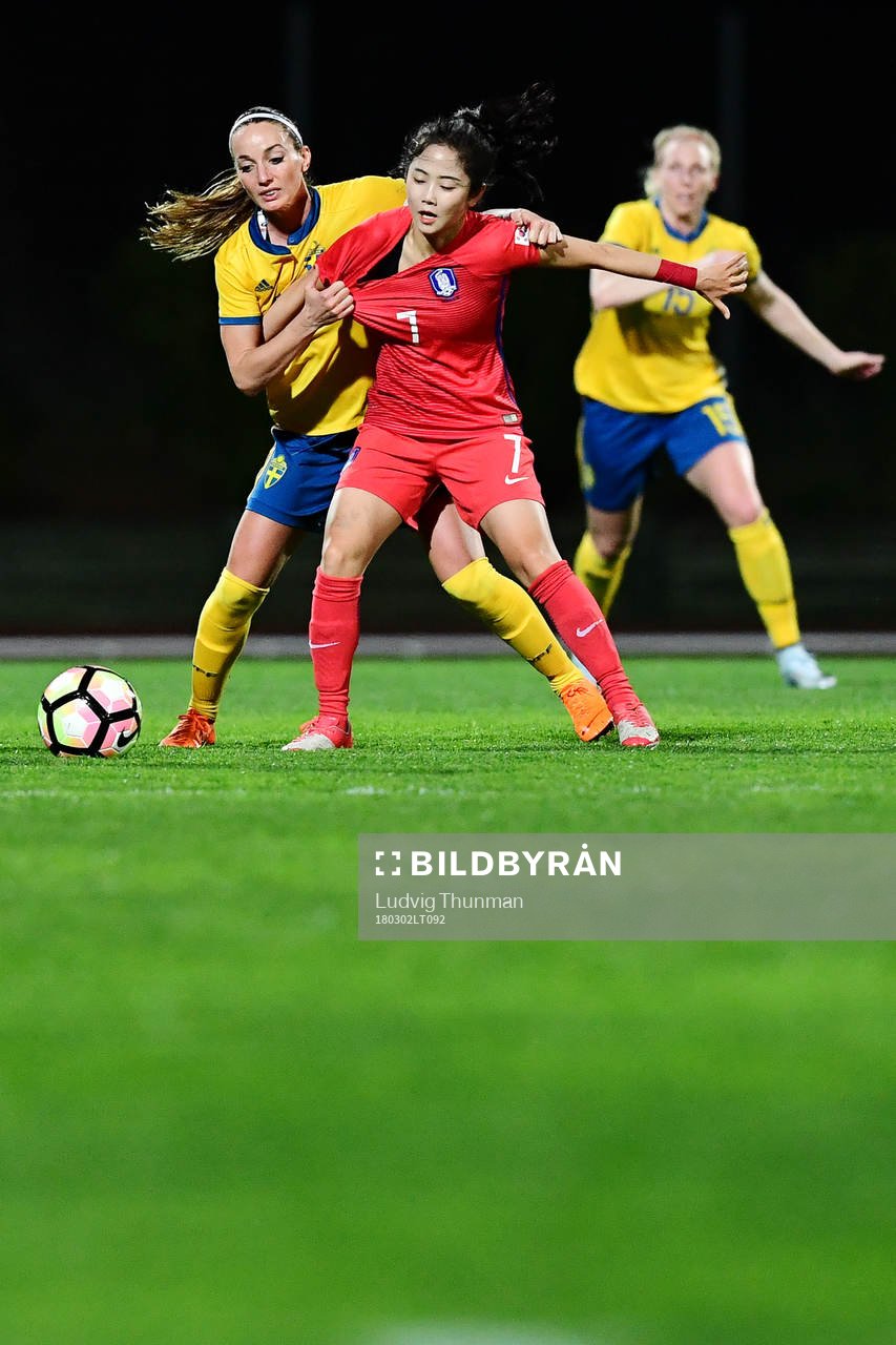 Sveriges Kosovare Asllani i kamp om bollen med Sydkoreas