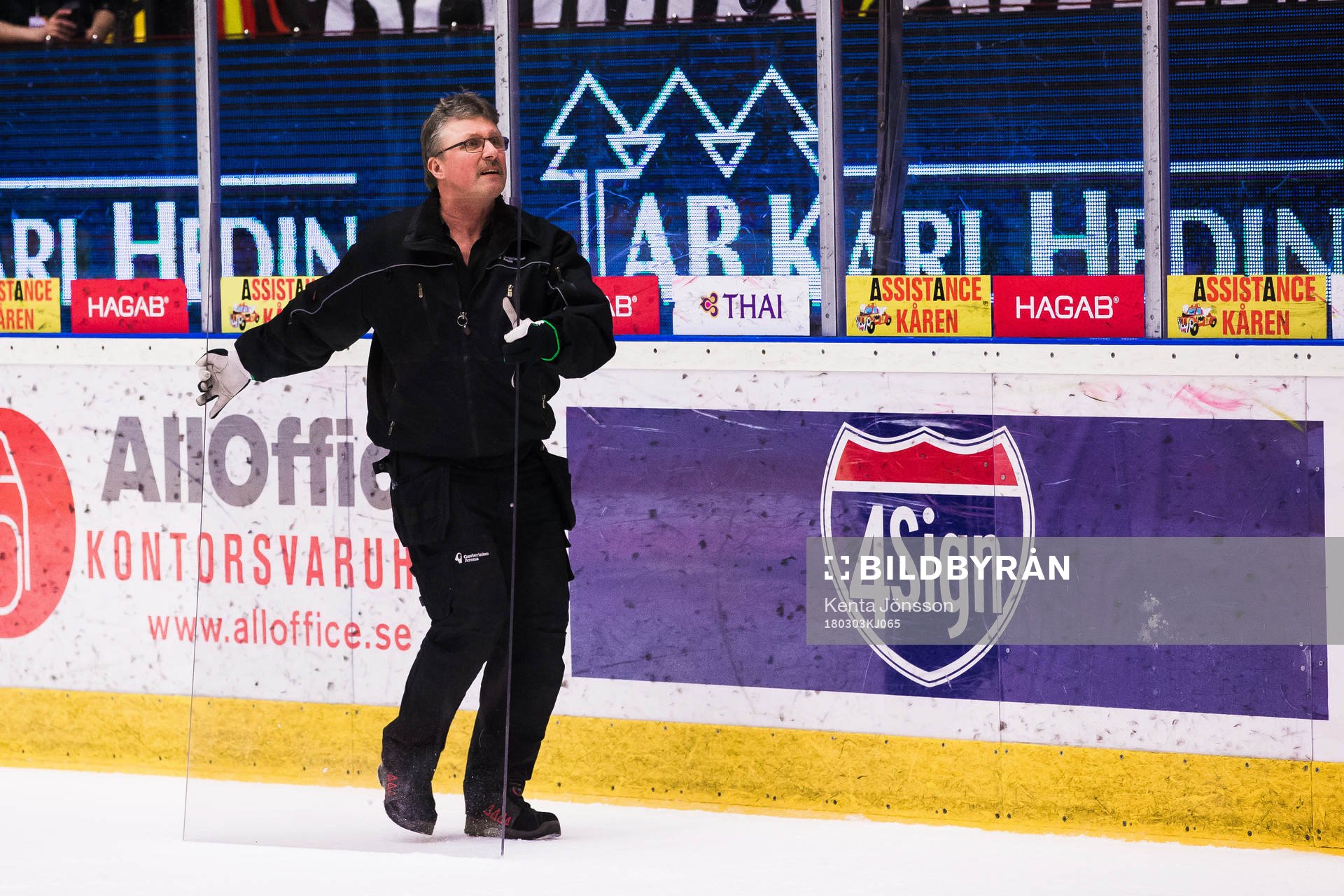 Personal med en skiva plexigas på isen