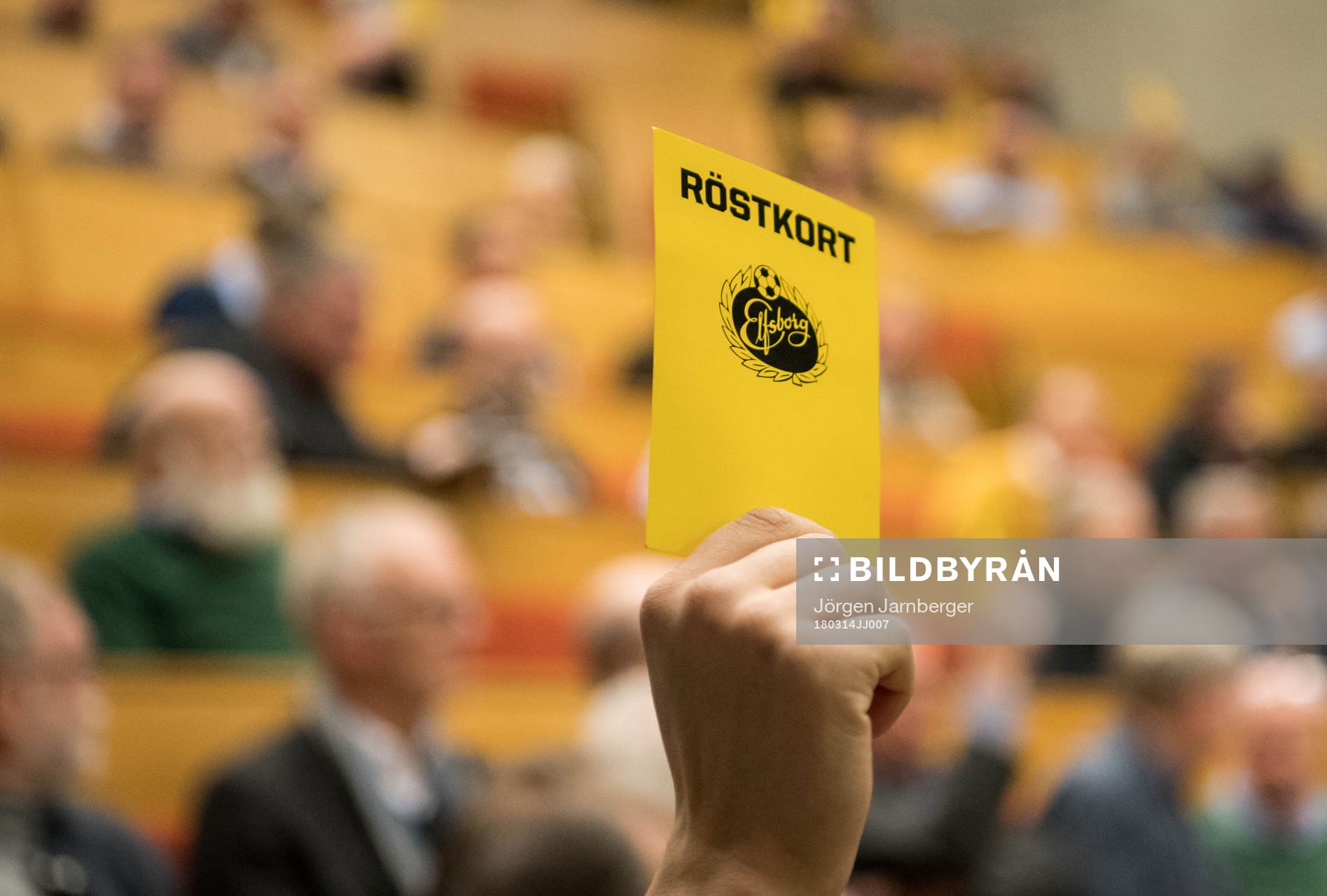 En medlem håller upp ett röstkort