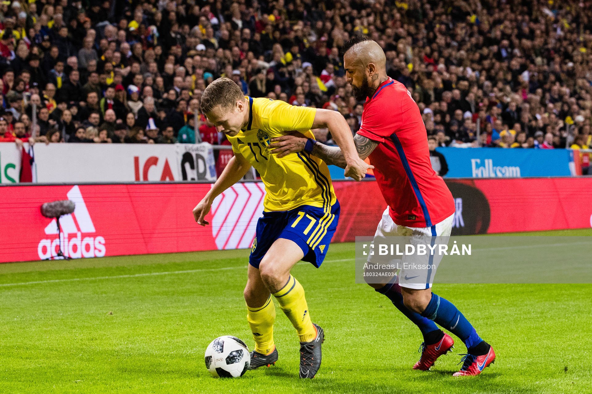 Sveriges Viktor Claesson i kamp om bollen med Chiles Arturo Vidal under träningslandskampen i fotboll mellan Sverige och Chile den 24 mars 2018 i Stockholm.