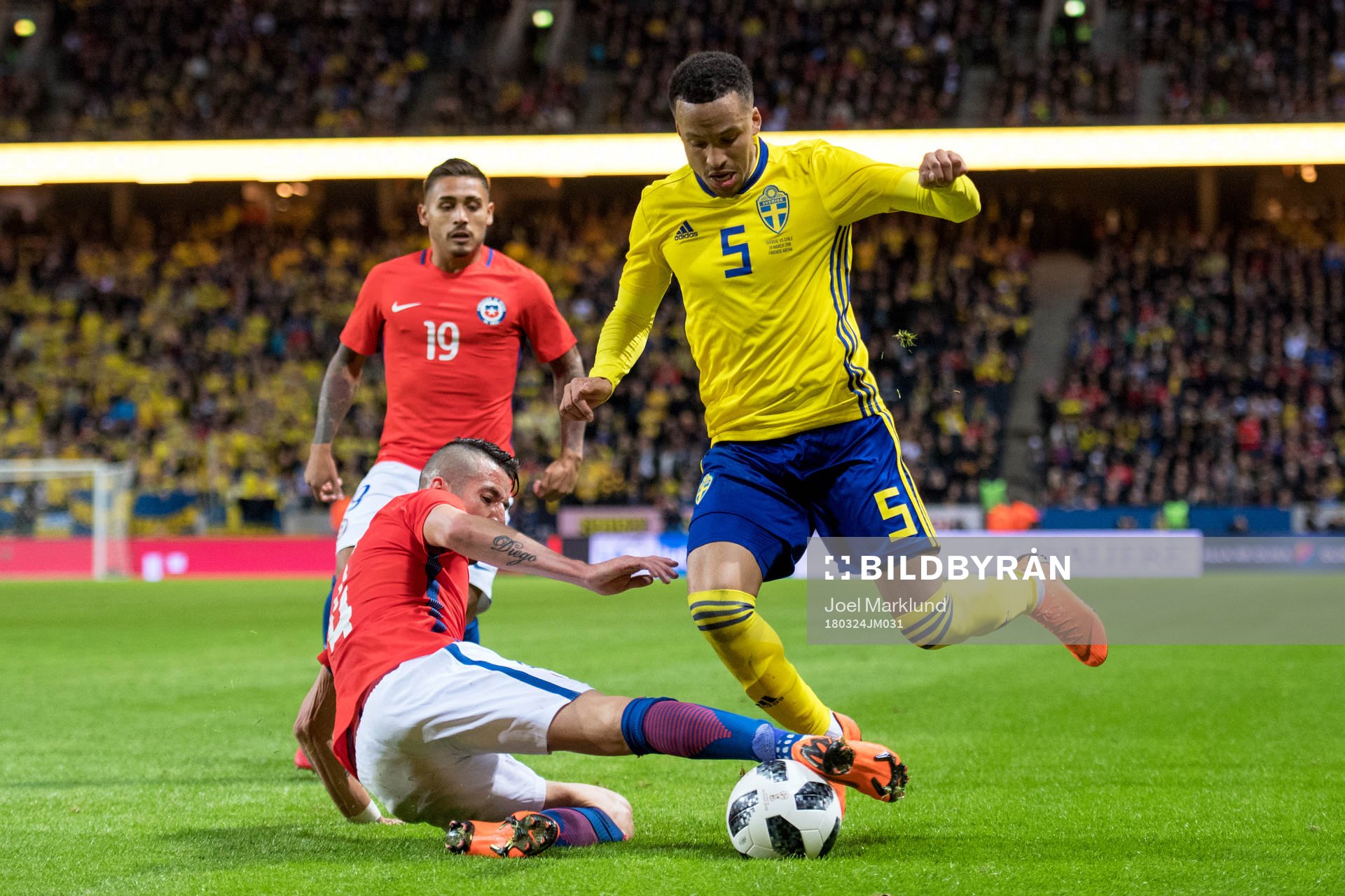 Chiles Mauricio Isla och Marcos Bolados och Sveriges Martin Olsson under träningslandskampen i fotboll mellan Sverige och Chile den 24 mars 2018 i Stockholm.