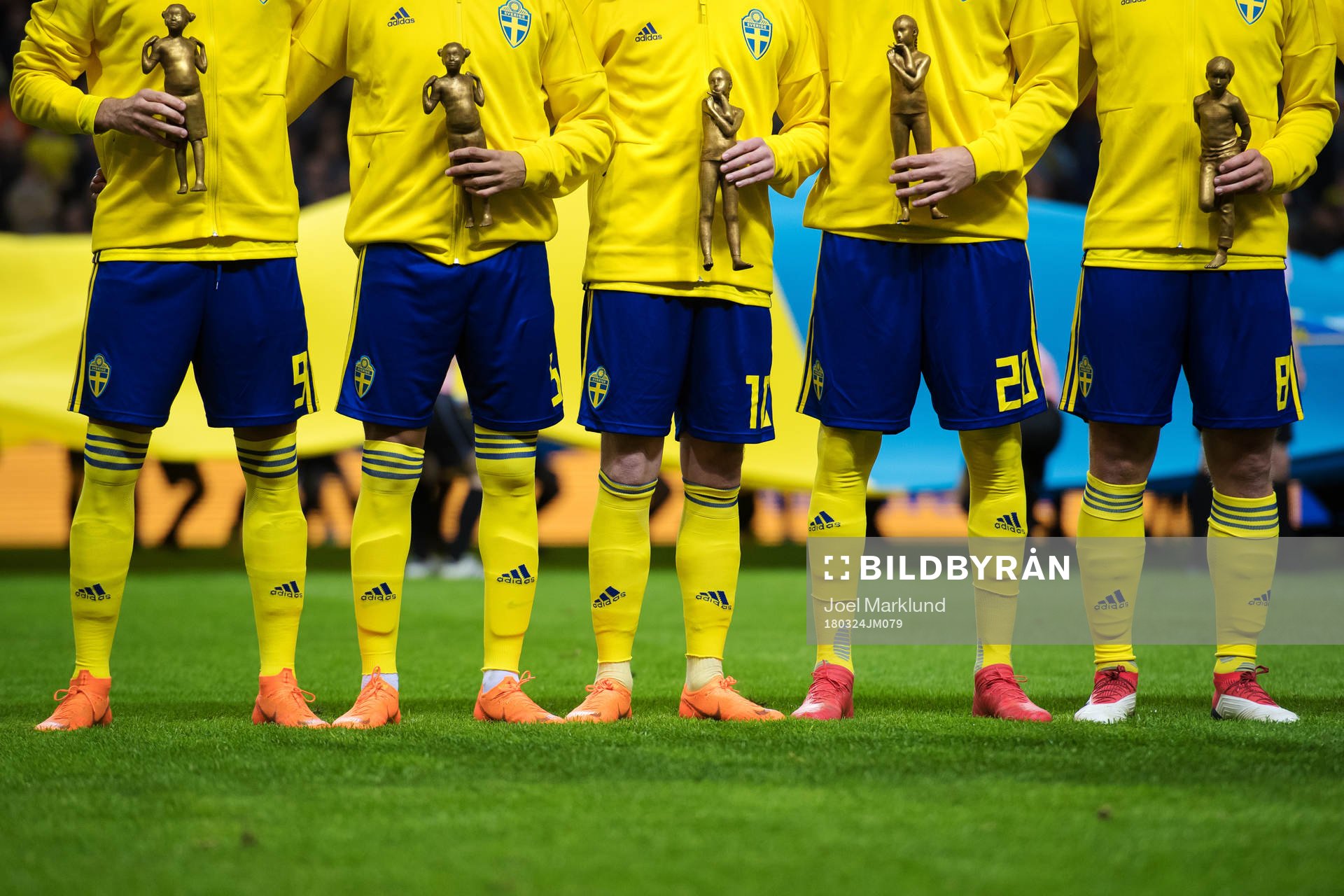 Sveriges spelare håller i statyer i en kampanj mot mobbning