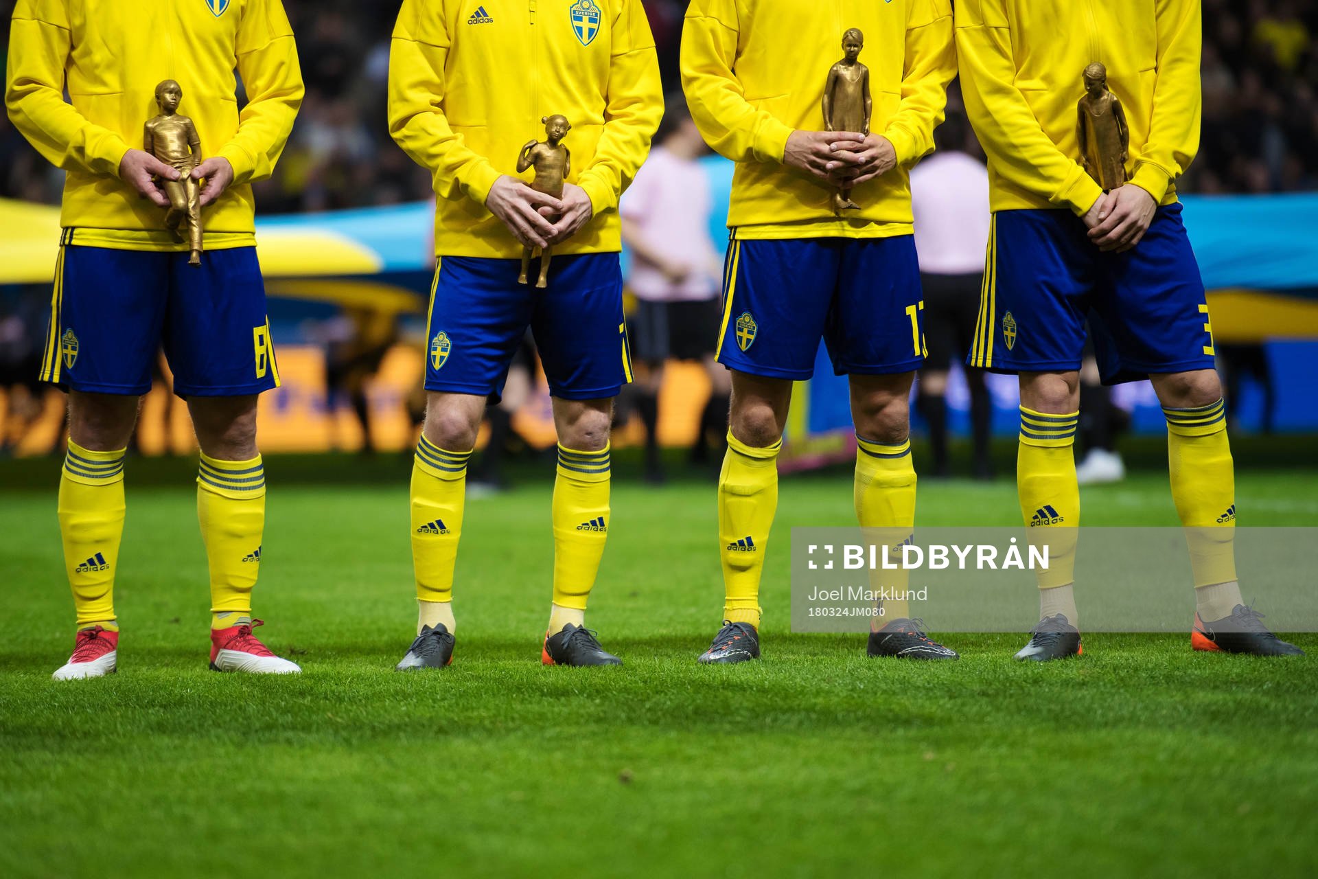 Sveriges spelare håller i statyer i en kampanj mot mobbning