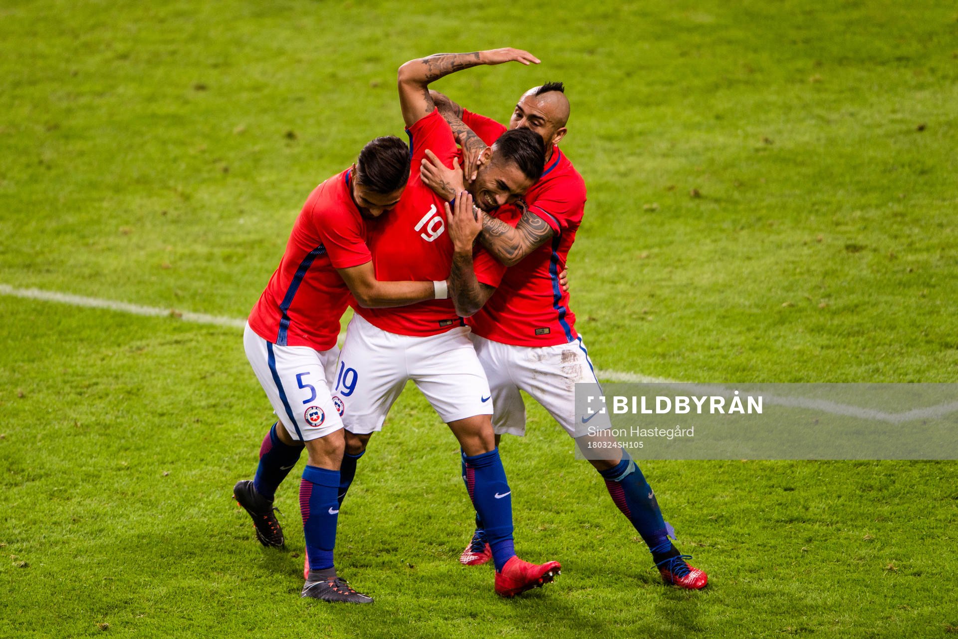 Chiles Marcos Bolados jublar med Paulo Diaz och Arturo Vidal efter 1-2 under träningslandskampen i fotboll mellan Sverige och Chile den 24 mars 2018 i Stockholm.
