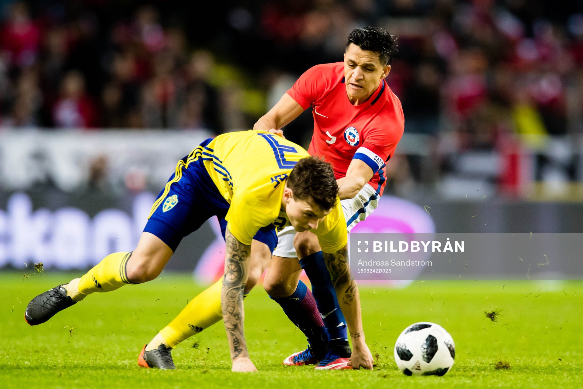 Chiles Alexis Sanchez i kamp med Sveriges Victor Nilsson Lindelöf under träningslandskampen i fotboll mellan Sverige och Chile den 24 Mars 2018 i Stockholm.
