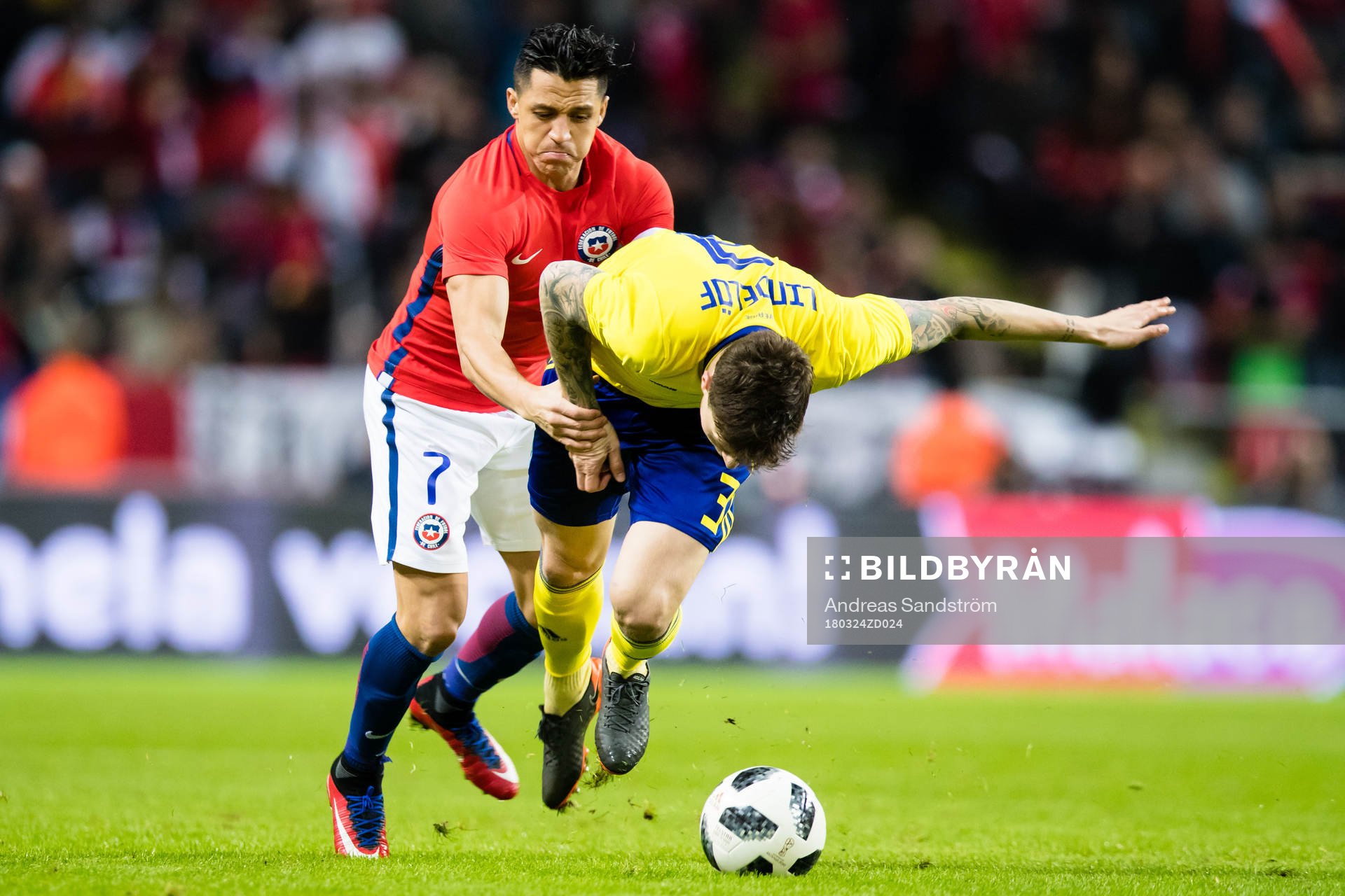 Chiles Alexis Sanchez i kamp med Sveriges Victor Nilsson Lindelöf under träningslandskampen i fotboll mellan Sverige och Chile den 24 Mars 2018 i Stockholm.