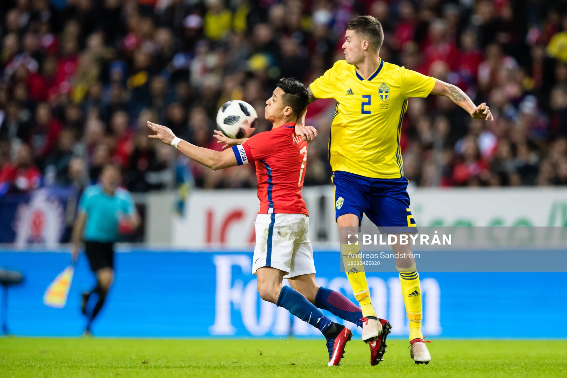 Chiles Alexis Sanchez i kamp med Sveriges Mikael Lustig under träningslandskampen i fotboll mellan Sverige och Chile den 24 Mars 2018 i Stockholm.