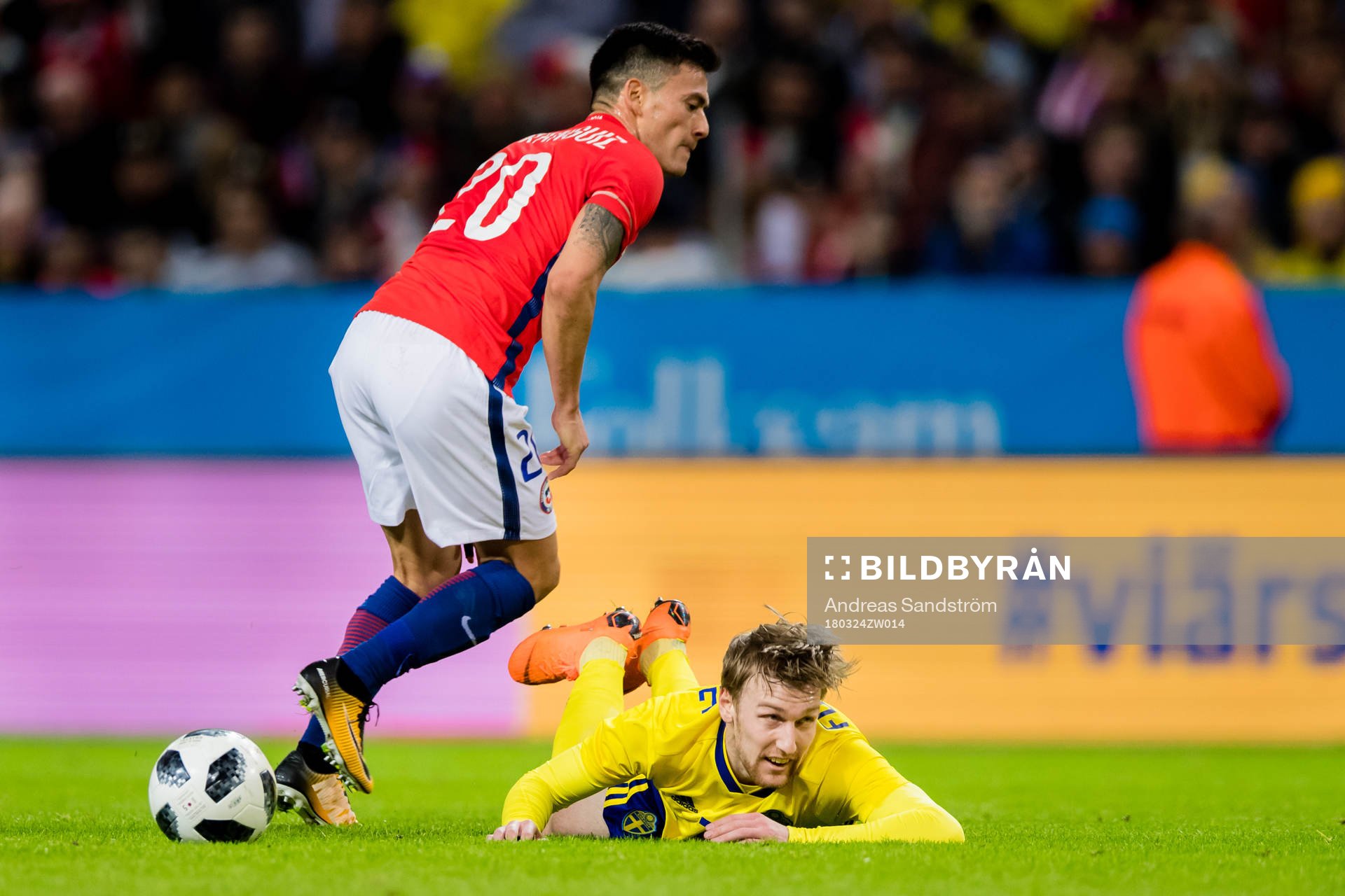 Sveriges Emil Forsberg faller i en duell med Chiles Charles