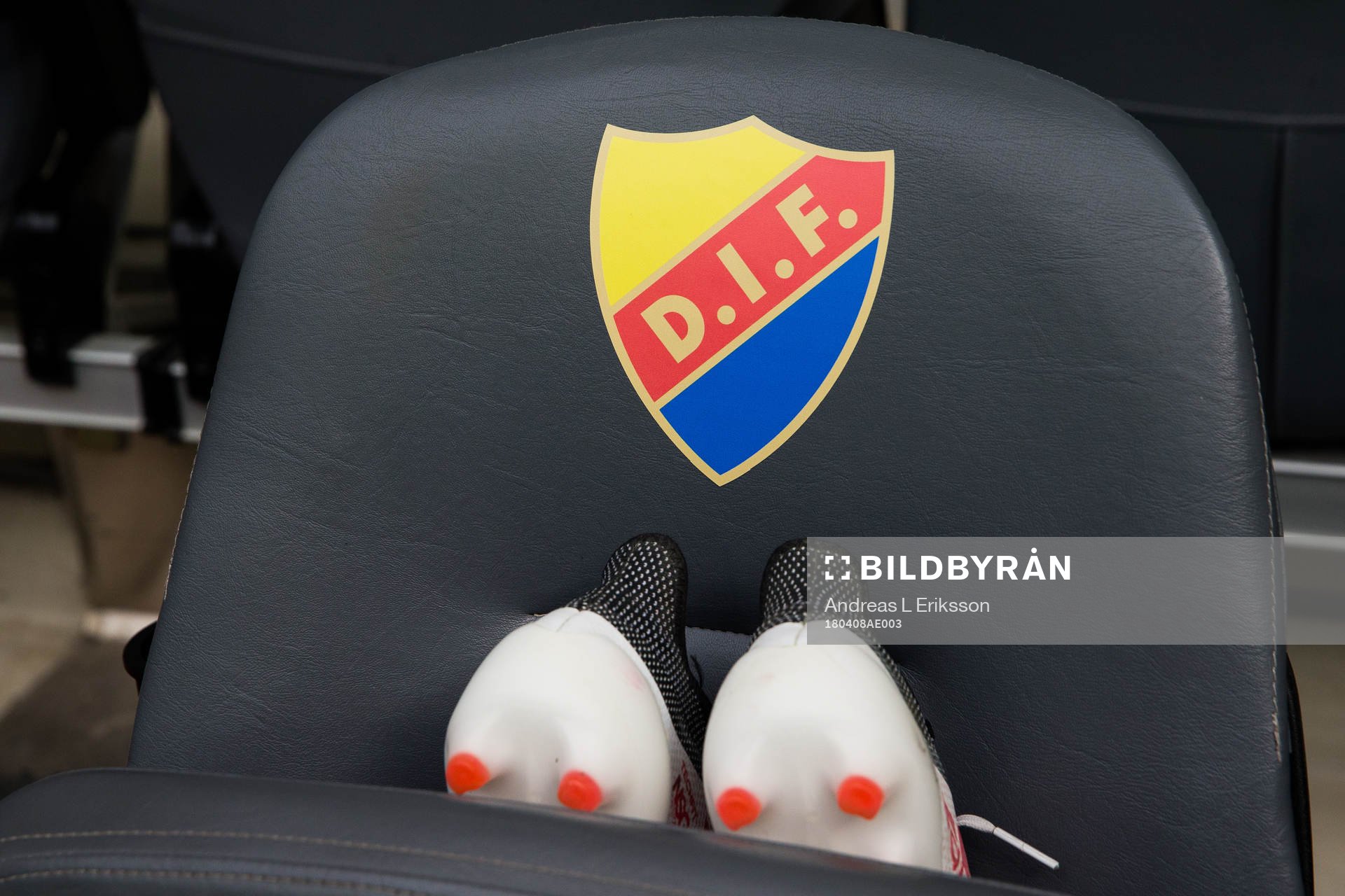 Djurgårdens emblem och ett par fotbollsskor på en stol
