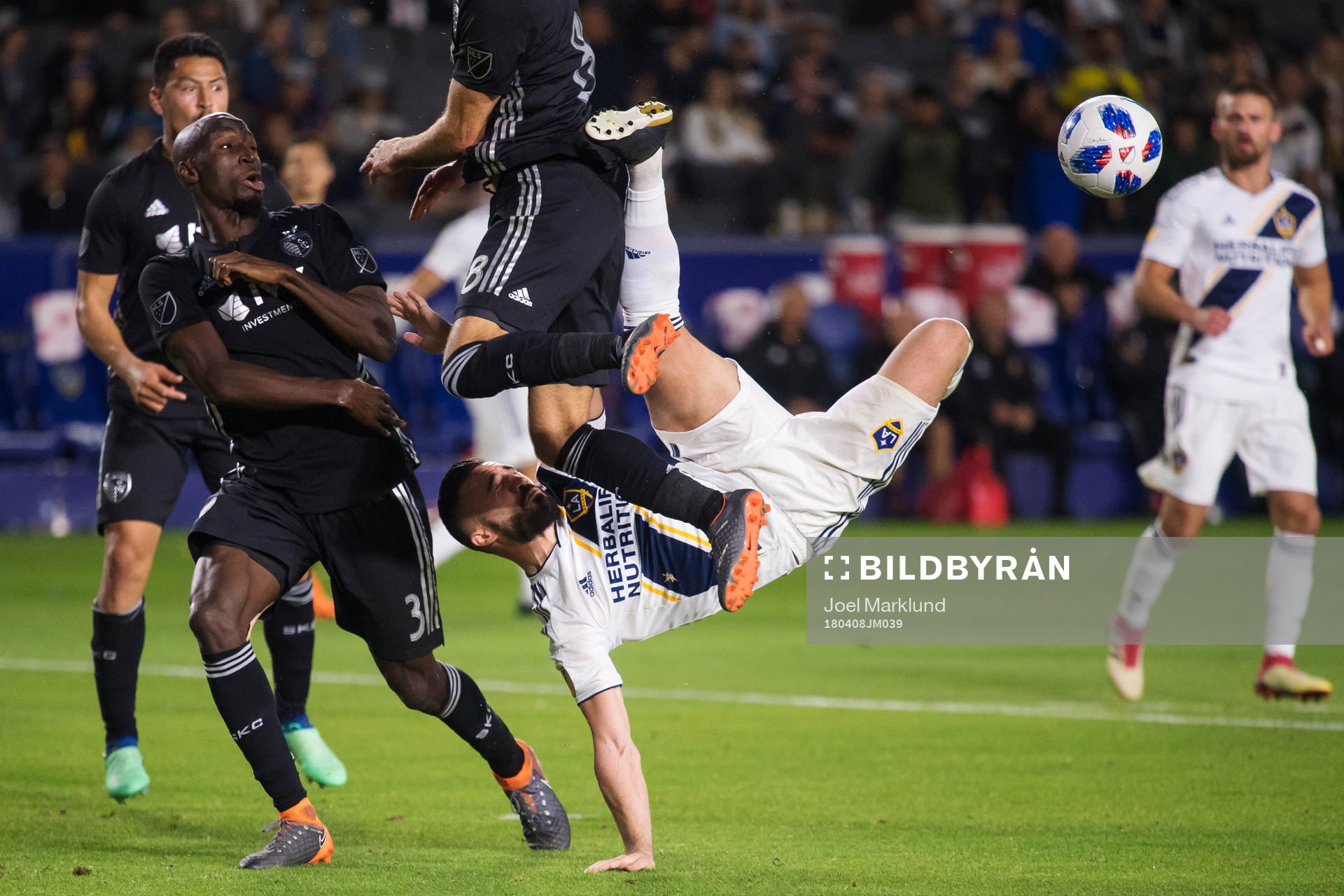LA Galaxys Romain Alessandrini utmanar Kansas Ike Opara och Graham Zusi när han försöker sig på en bicykleta under fotbollsmatchen i MLS mellan LA Galaxy och Sporting Kansas City den 8 april 2018 i Los Angeles.