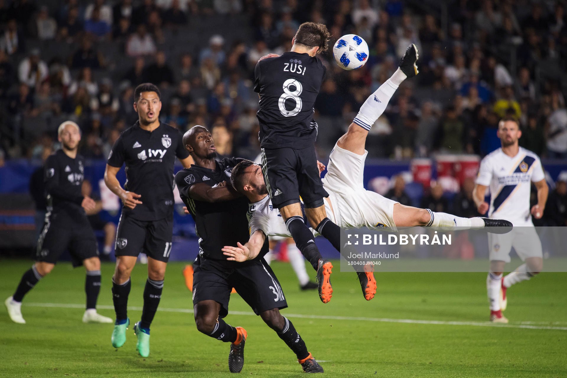 LA Galaxys Romain Alessandrini utmanar Kansas Ike Opara och Graham Zusi när han försöker sig på en bicykleta under fotbollsmatchen i MLS mellan LA Galaxy och Sporting Kansas City den 8 april 2018 i Los Angeles.