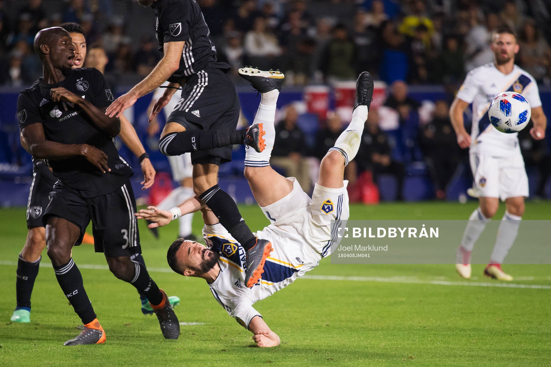 LA Galaxys Romain Alessandrini utmanar Kansas Ike Opara och Graham Zusi när han försöker sig på en bicykleta under fotbollsmatchen i MLS mellan LA Galaxy och Sporting Kansas City den 8 april 2018 i Los Angeles.