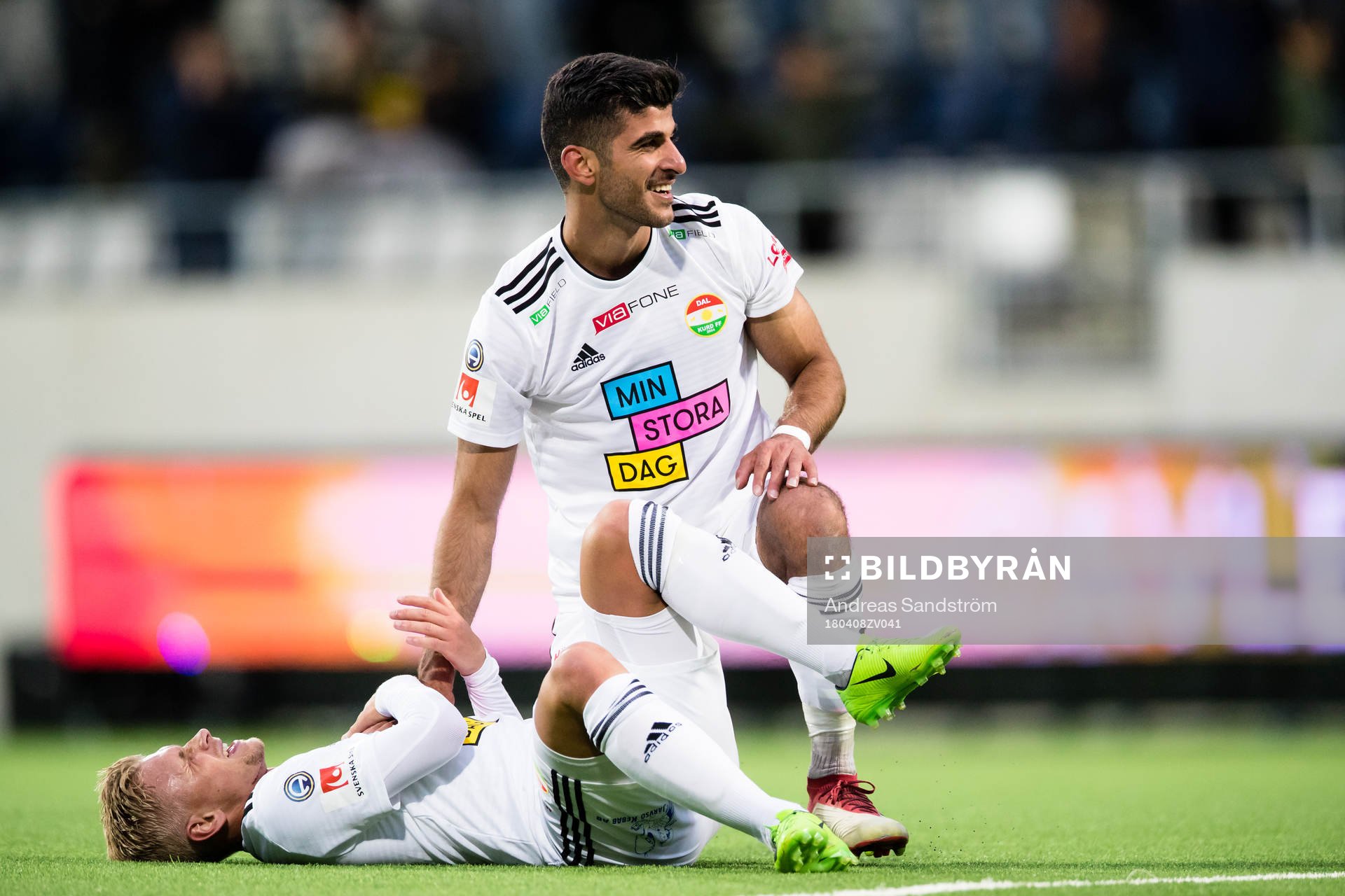 Dalkurds Rewan Amin omfamnar en liggande Simon Strand