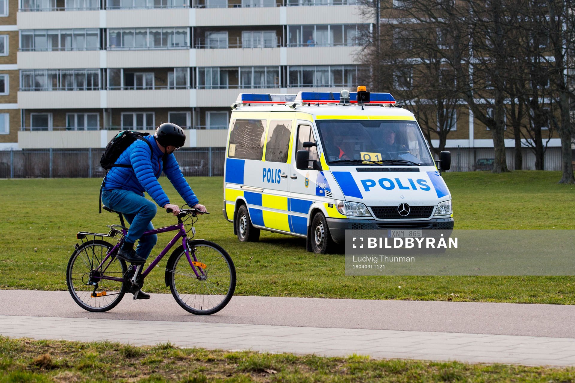 En cyklist passerar en polisbil