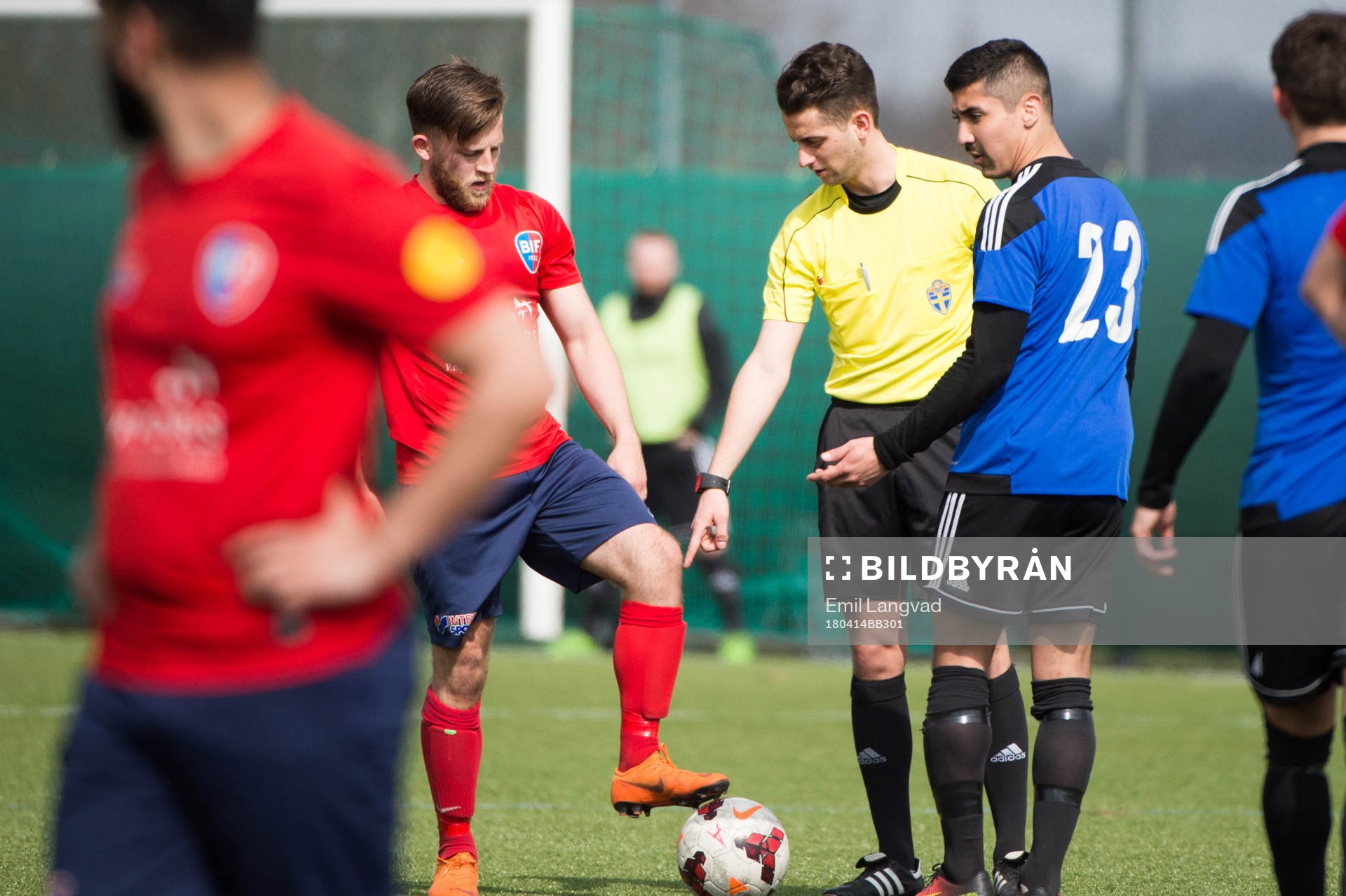 Bjärreds Steven Lawless, domare Nikola Pavlovic och Lilla Torgs Diego Delgado Forrich under fotbollsmatchen i division 4 sydvästra mellan Bjärred och Lilla Torg den 14 april 2018 i Bjärred.