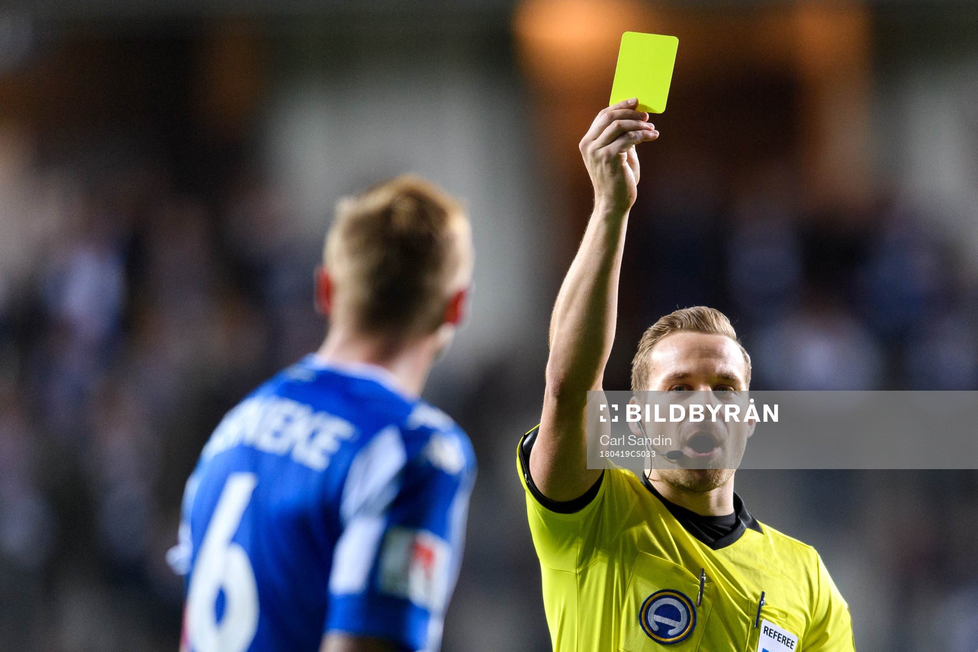 Domare Kristoffer Karlsson delar ut ett gult kort