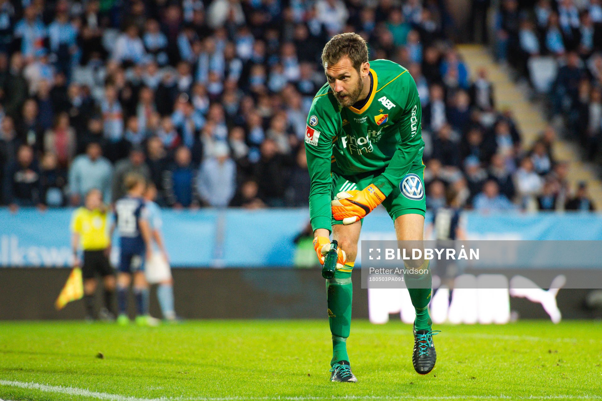 Djurgårdens målvakt Andreas Isaksson rensar bort en ölflaska som blivit inkastad på planen under fotbollsmatchen i Allsvenskan mellan Malmö FF och Djurgården den 3 maj 2018 i Malmö.