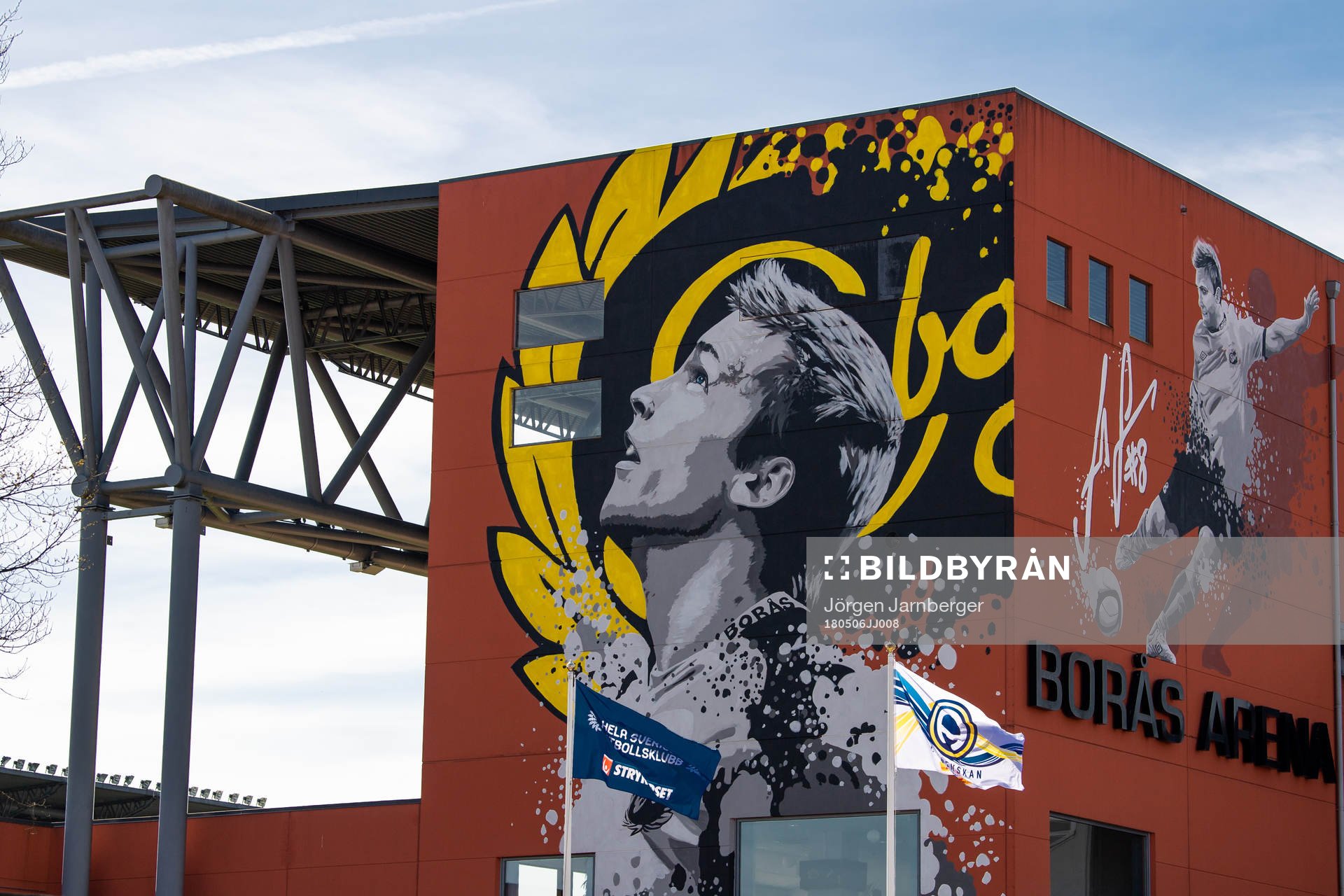 Flaggor vajar framför muralmålningen på Borås arena