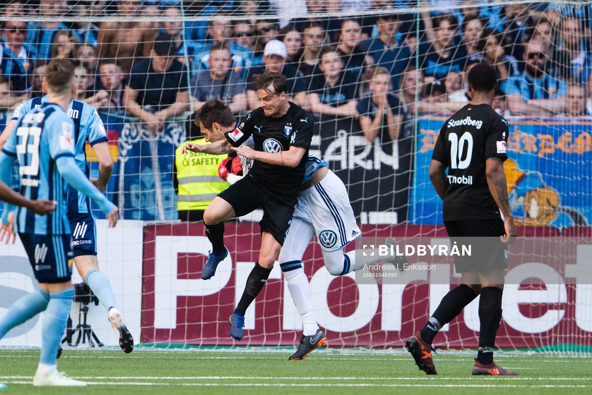 Malmö FFs Eric Larsson tacklar Djurgårdens målvakt