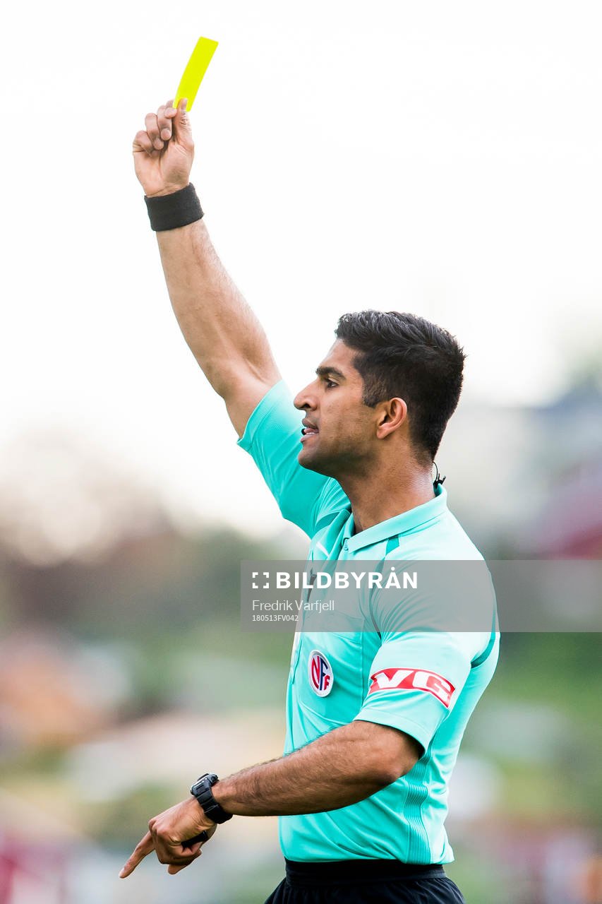 Mohammad Usman Aslam, referee, shows a yellow card