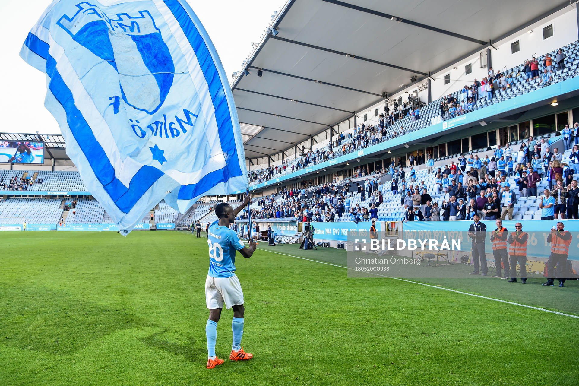 Malmö FFs Bonke Innocent jublar med en flagga i handen mot publiken efter vinsten i fotbollsmatchen i Allsvenskan mellan Malmö FF och Häcken den 20 maj 2018 i Malmö.