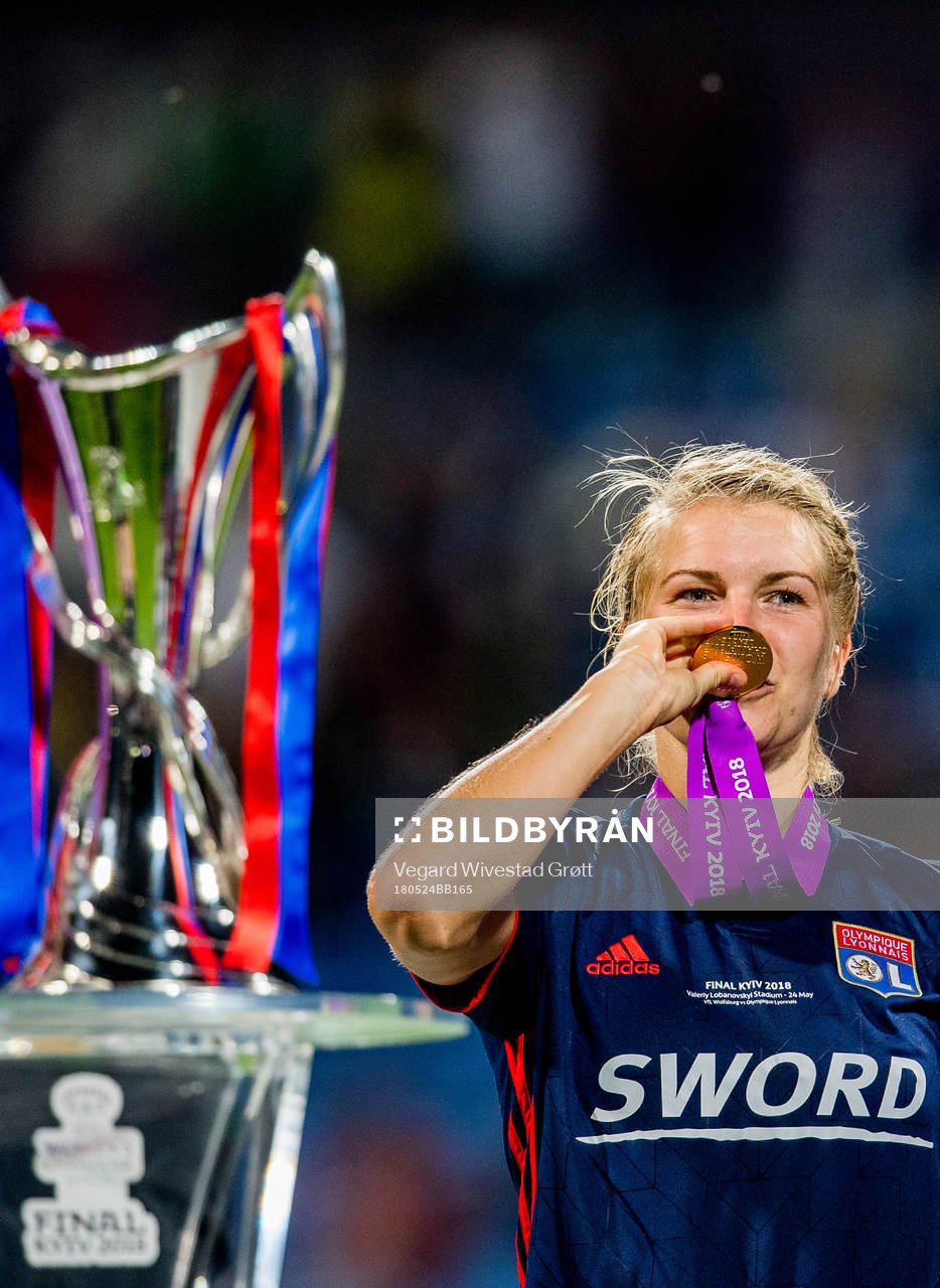 Ada Hegerberg of Lyon celebrates next to the trophy