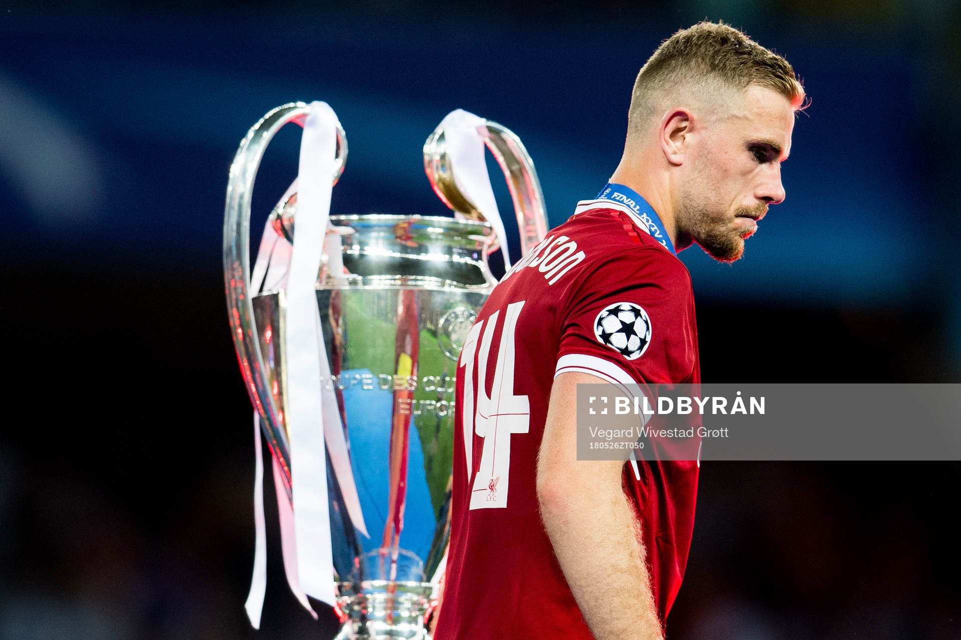 Jordan Henderson of Liverpool walks dejected past the trophy