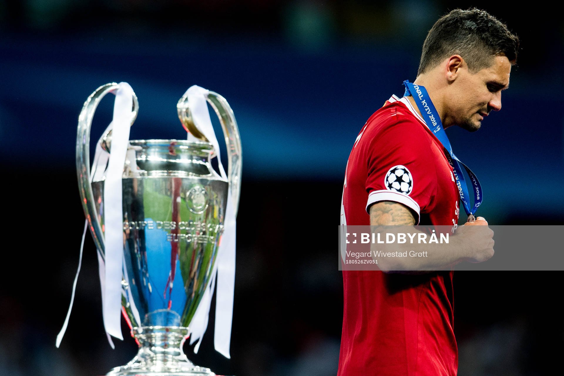 Dejan Lovren of Liverpool walks dejected past the trophy