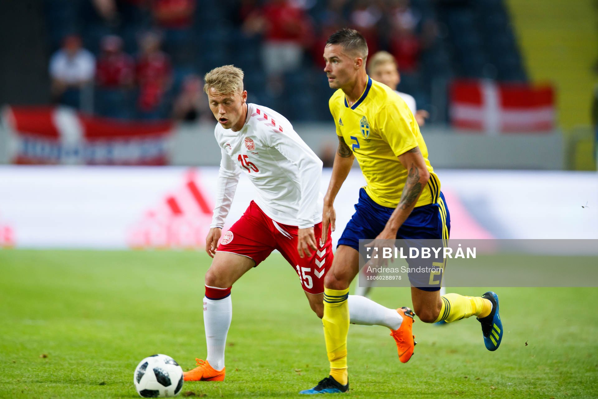 Danmarks målvakt Jonas Lössl jagar Sveriges Mikael Lustig