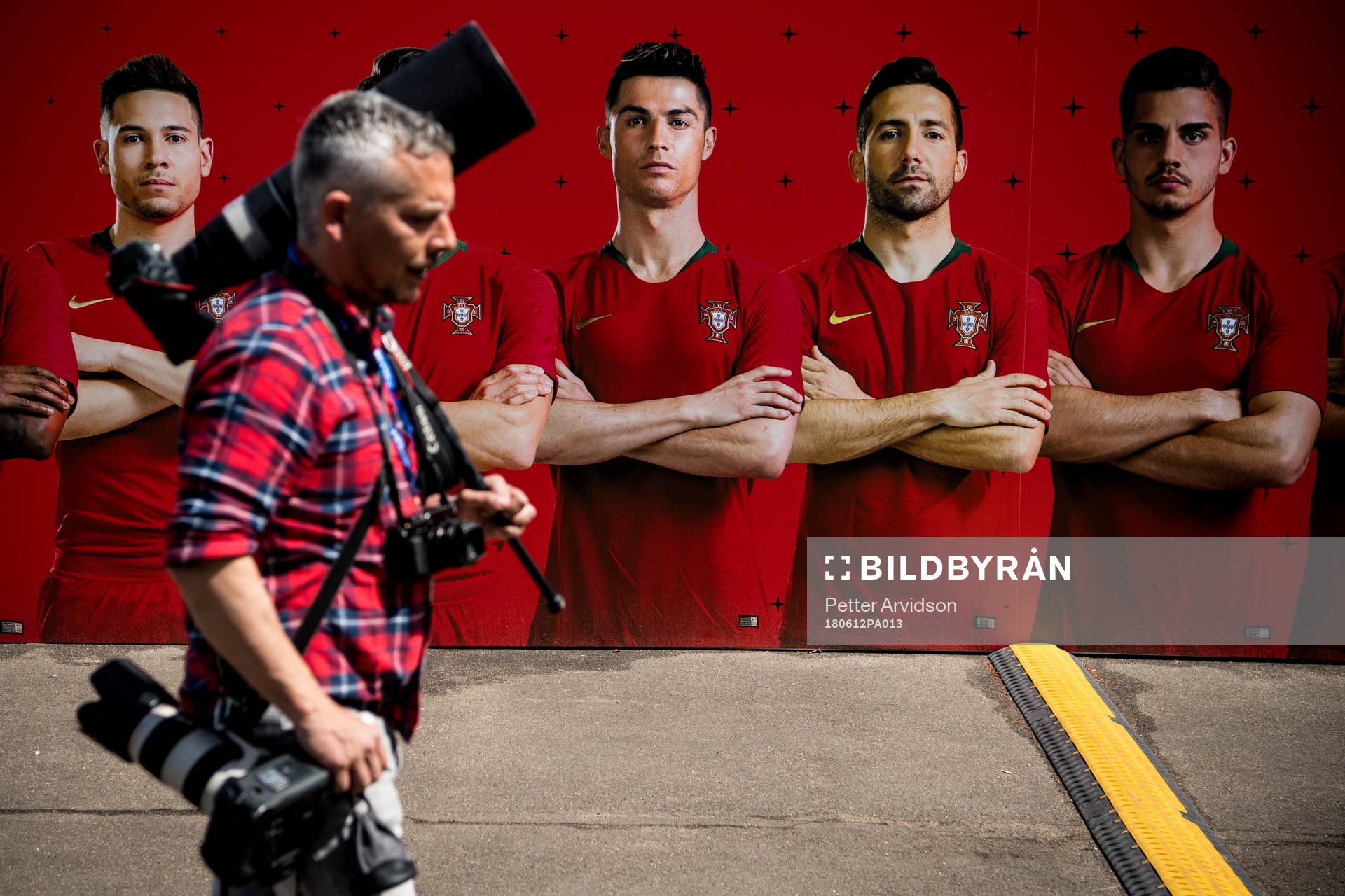 A member of the press walks by a banner with the Portuguese