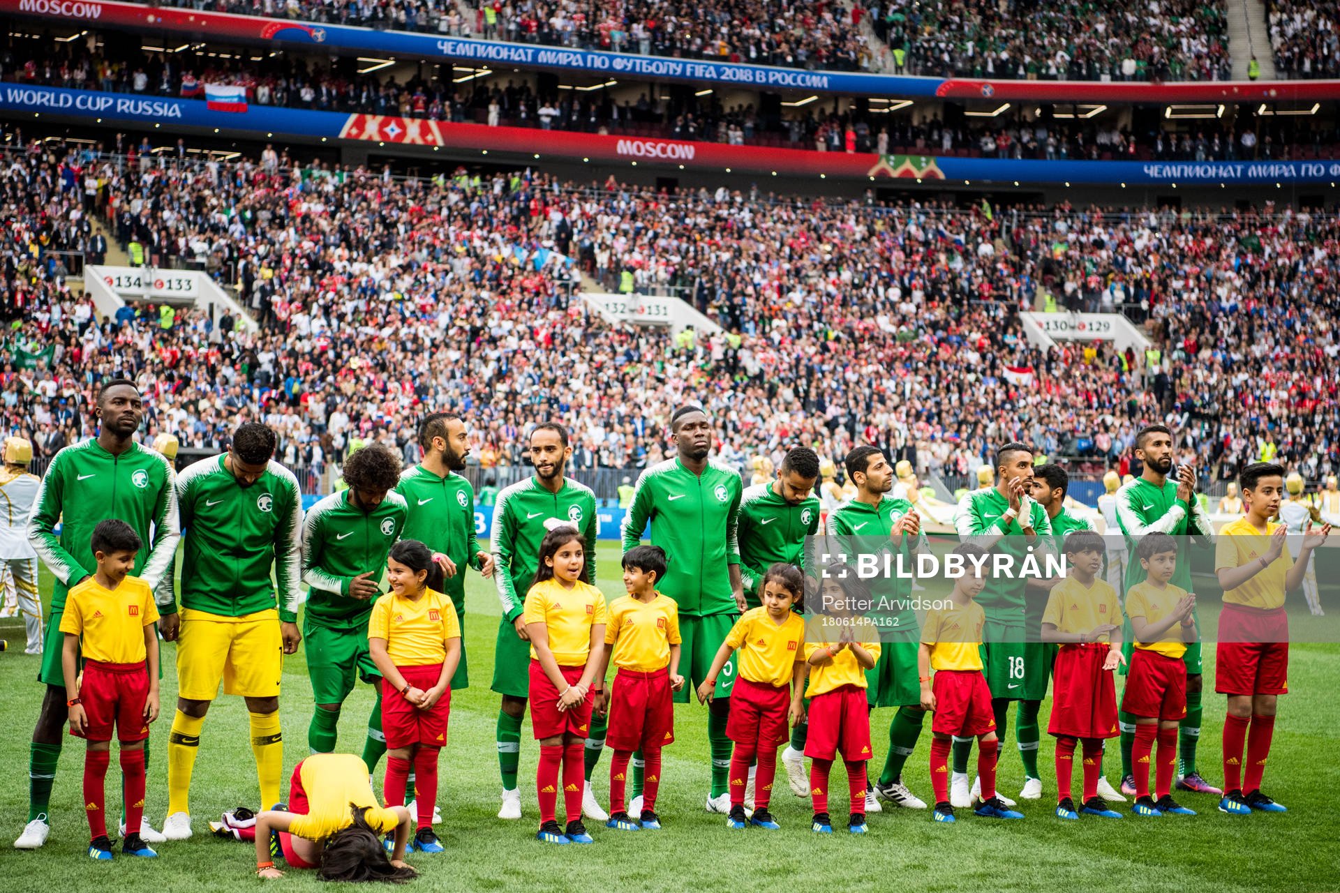 A mascot girl prays in front of the players of Saudi Arabia