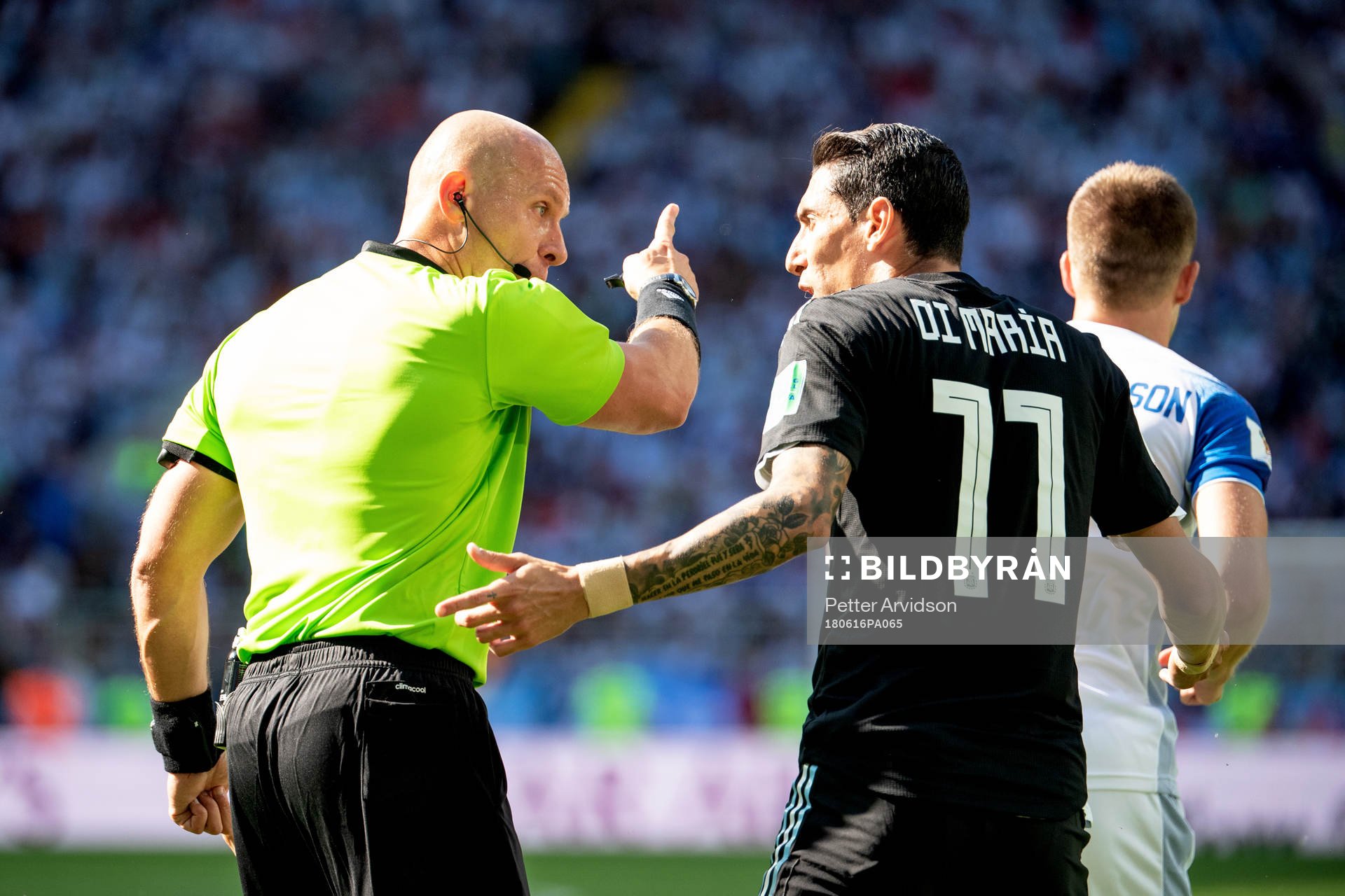 referee Szymon Marciniak and Angel Di Maria of Argentina