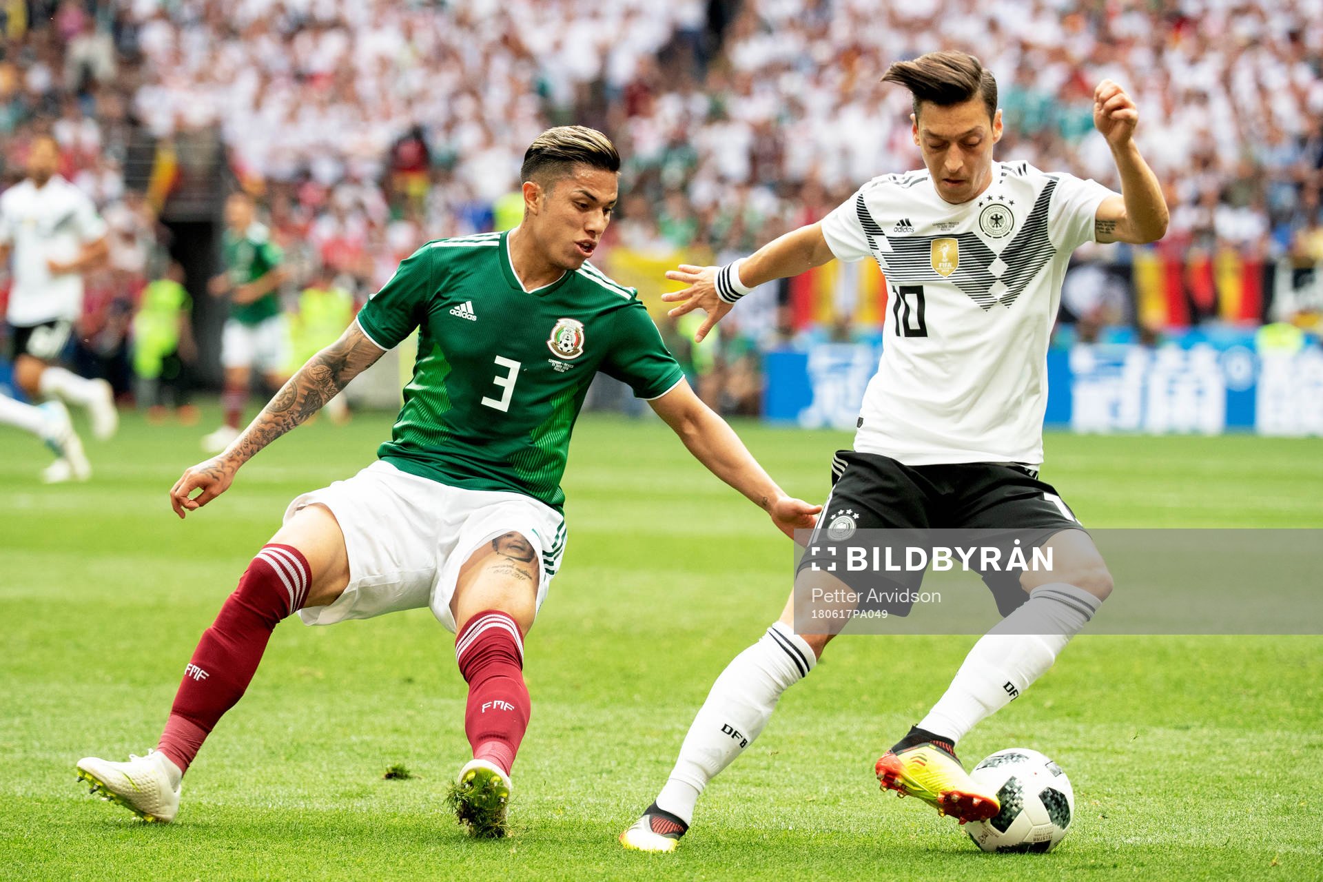 Carlos Salcedo of Mexico and Mesut Özil of Germany