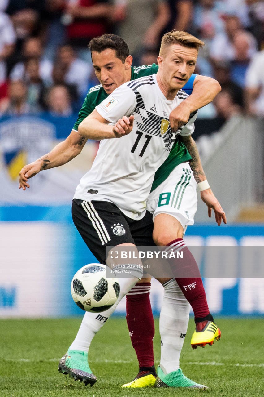Marco Reus of Germany in action with Andres Guardado of