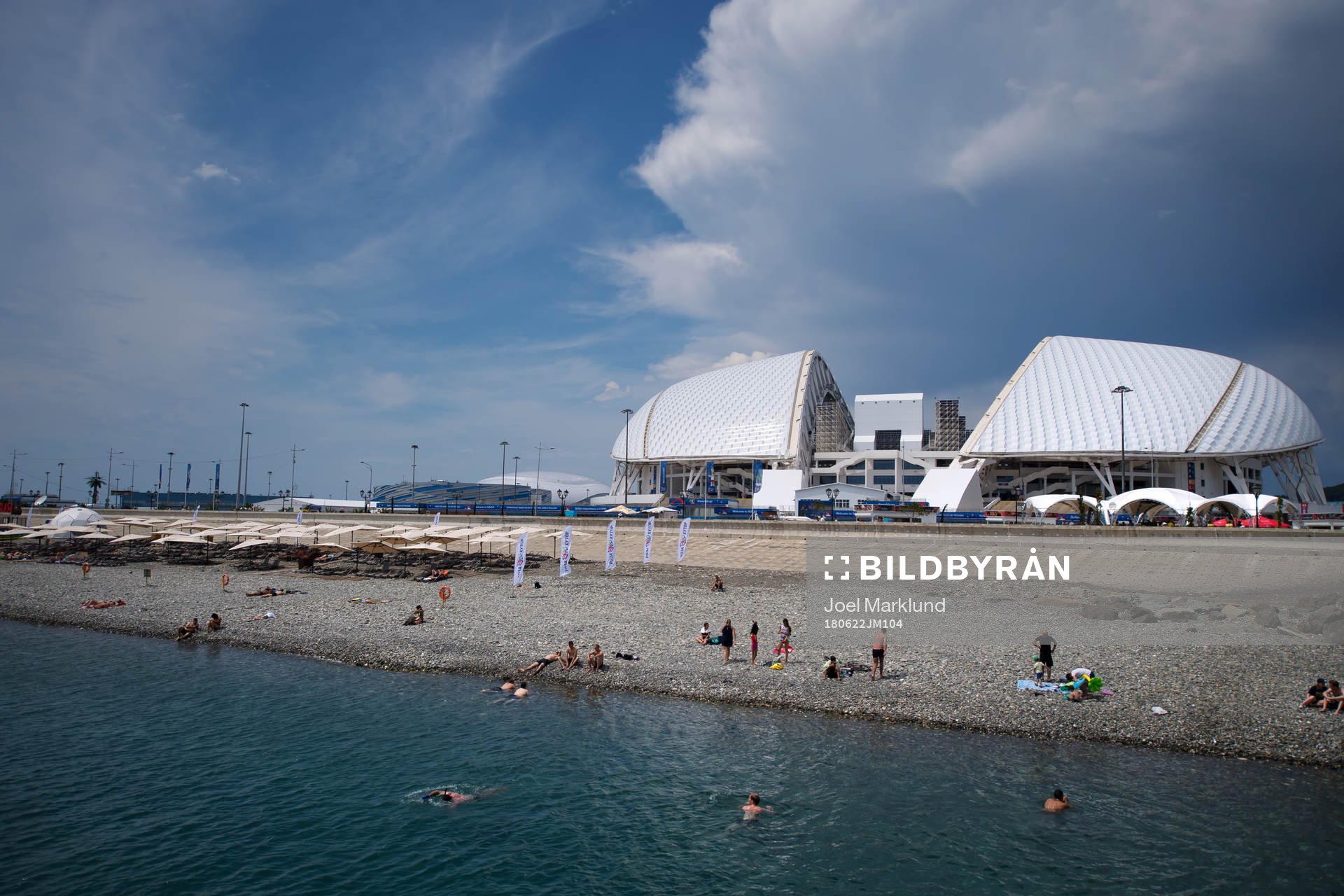 People bathing in front of Fisht Stadium
