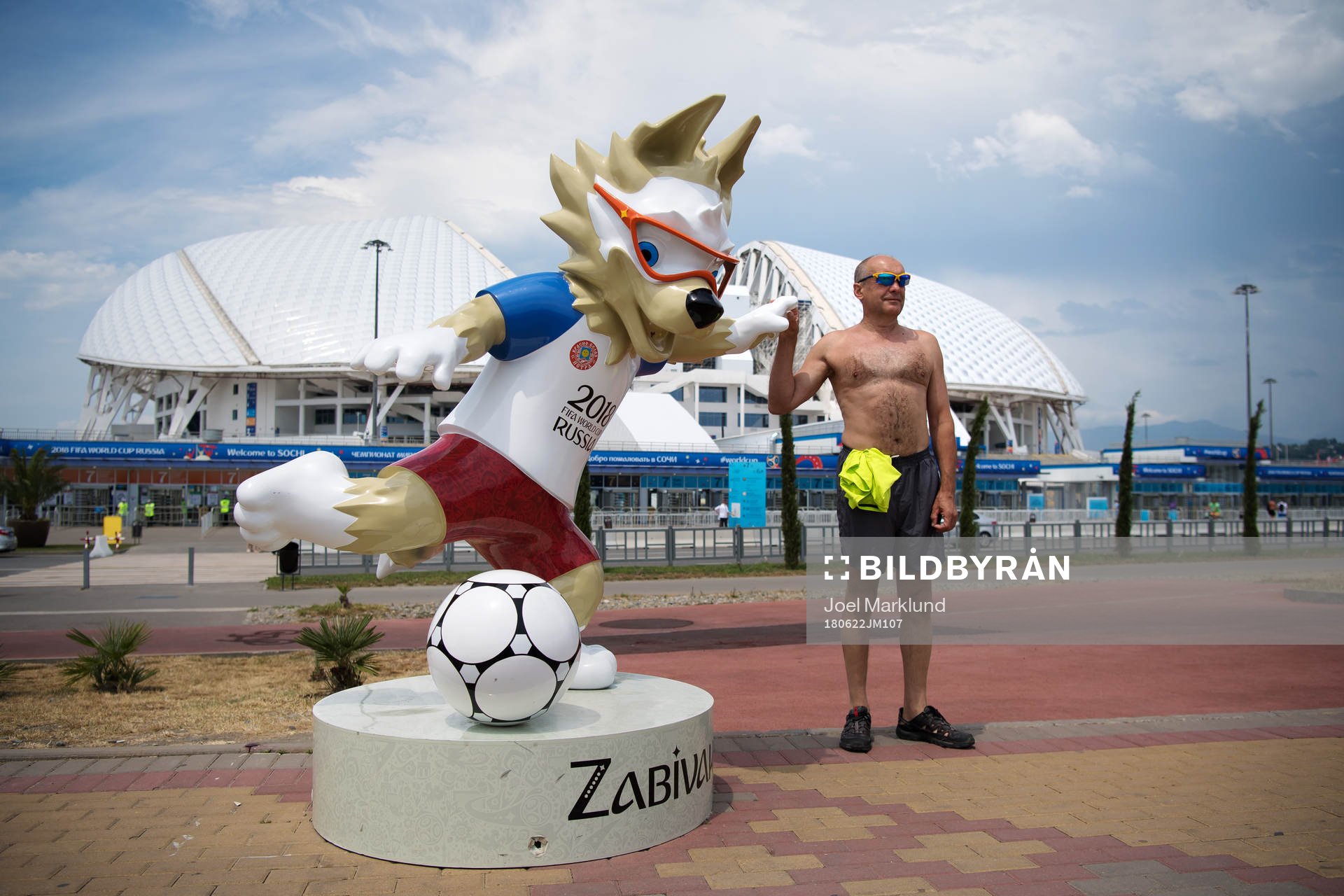 An man poses with the 2018 World Cup mascot Zabivaka in
