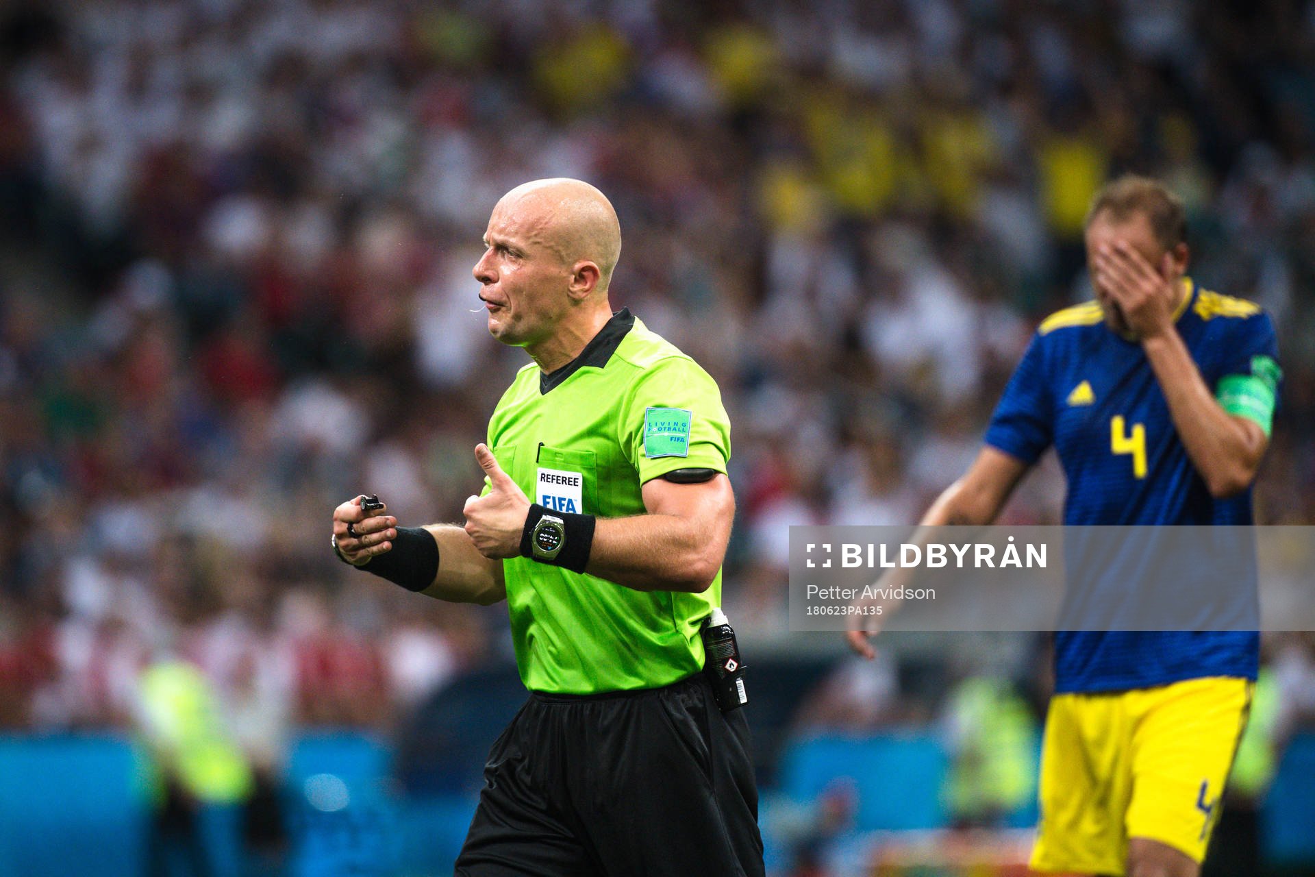 referee Szymon Marciniak and Andreas Granqvist of Sweden