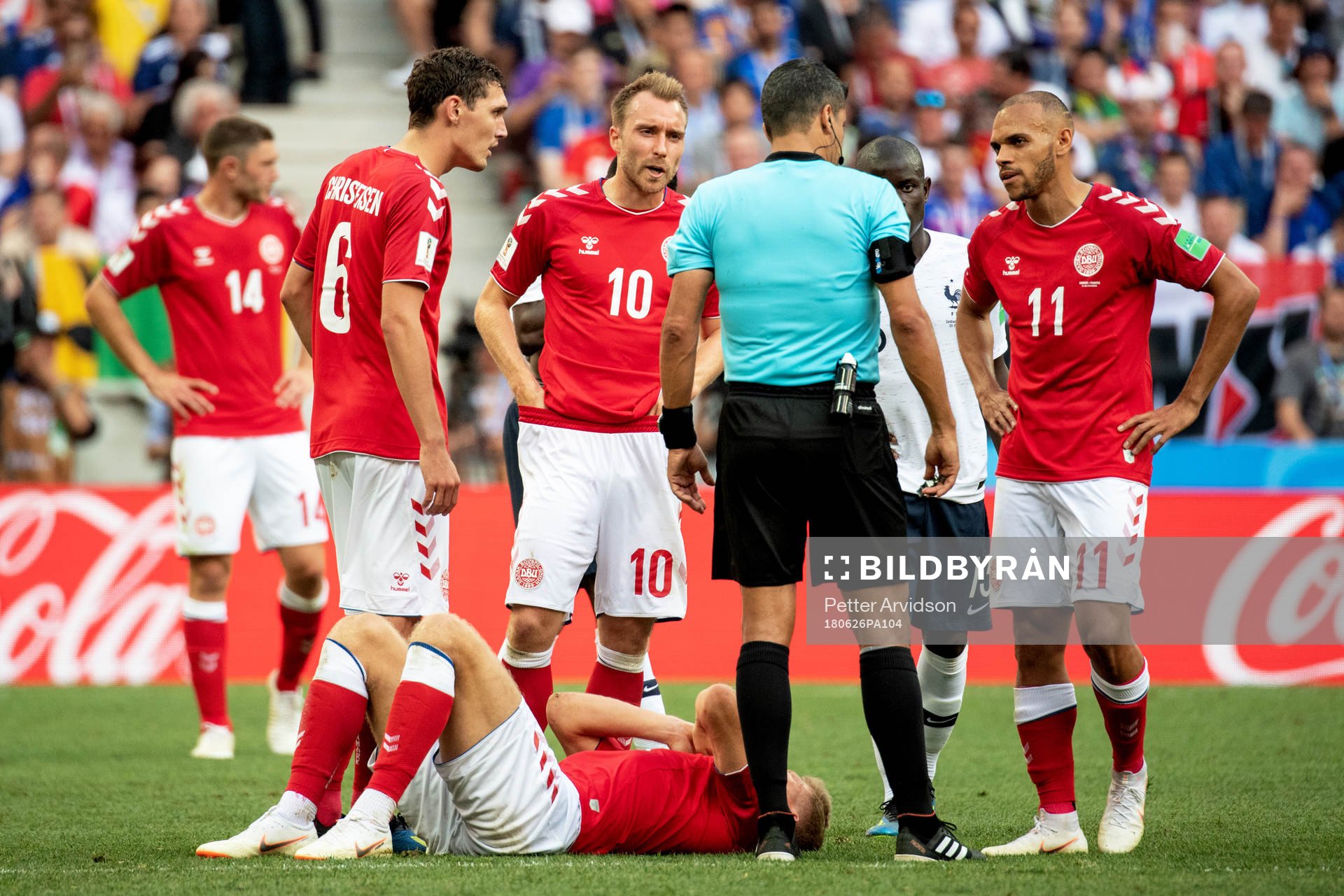Players of Denmark talks to referee Sandro Ricci