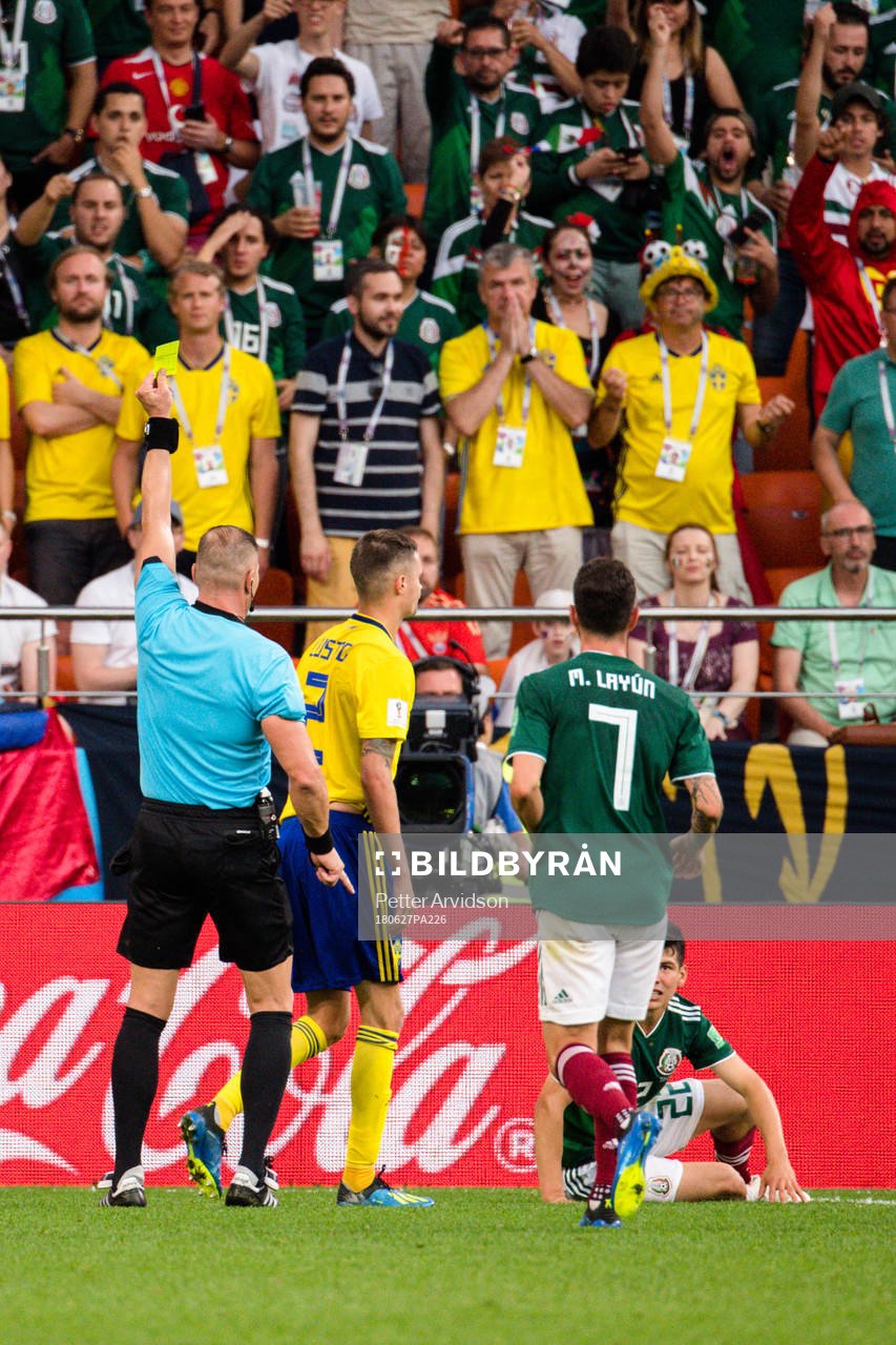 Mikael Lustig of Sweden receives a yellow card