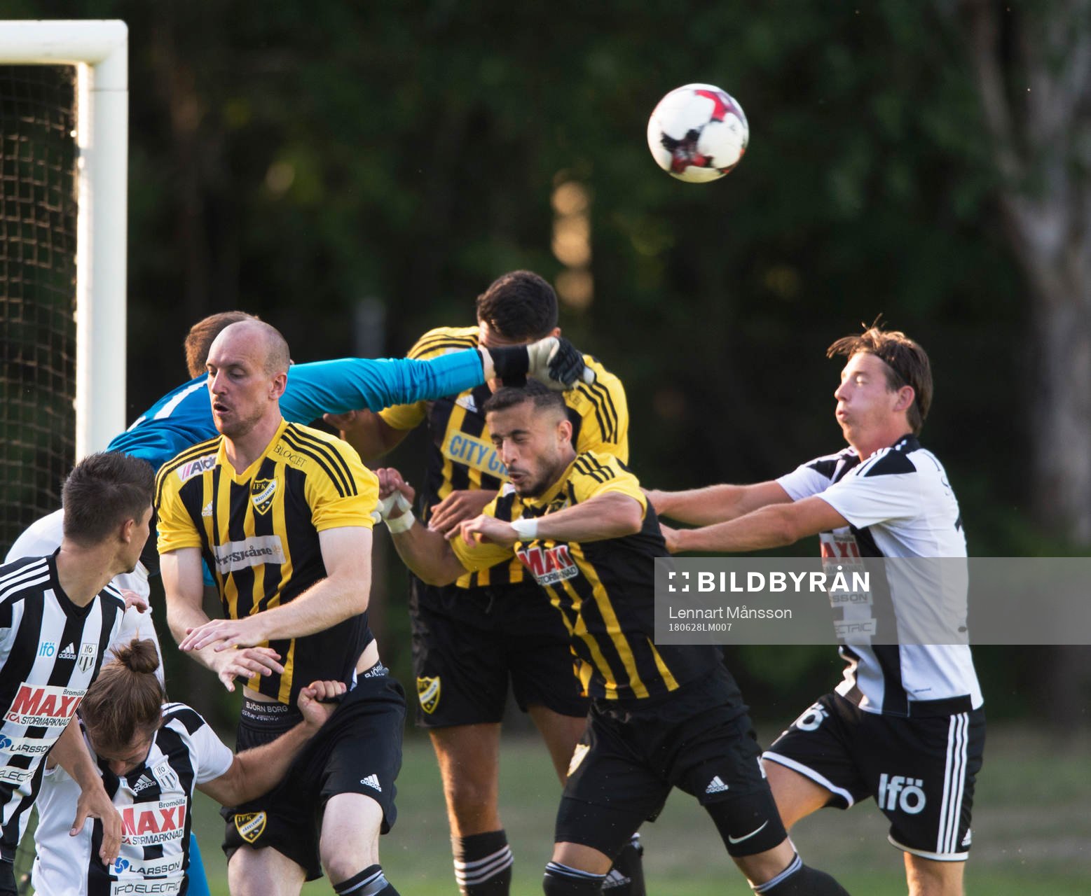 IFK Hässleholms målvakt Adam Larsson boxar bort framför Simon Henningsson, Tommy Filipovic och Mohamed Hamdan i matchen i division 2 mellan Bromölla och IFK Hässleholm i Bromölla 28 juni 2018.