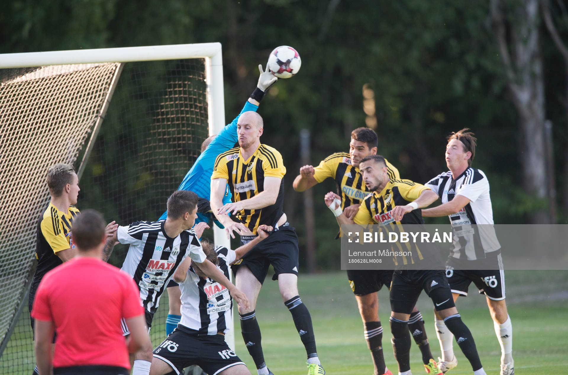 IFK Hässleholms målvakt Adam Larsson boxar bort framför Simon Henningsson, Tommy Filipovic och Mohamed Hamdan i matchen i division 2 mellan Bromölla och IFK Hässleholm i Bromölla 28 juni 2018.