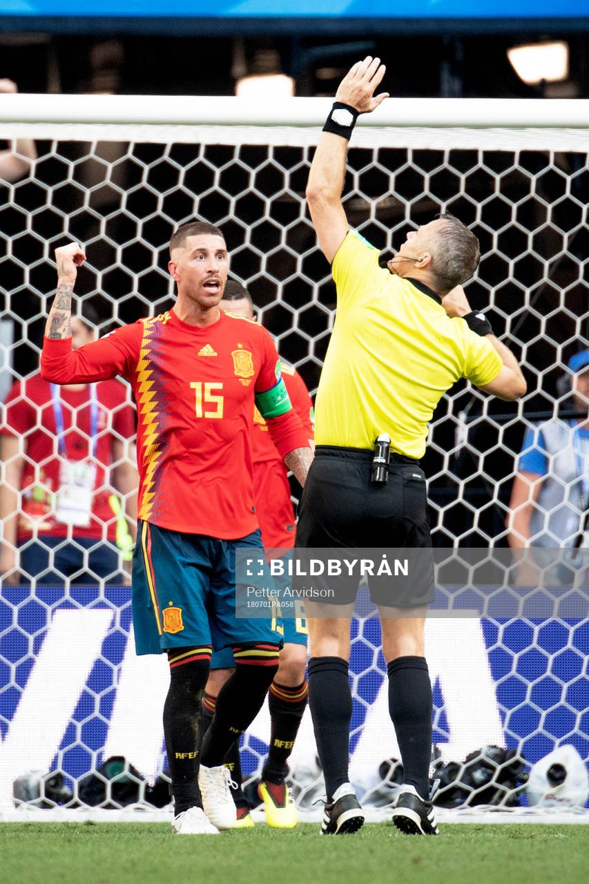 Handball by Gerard Pique of Spain and referee Björn